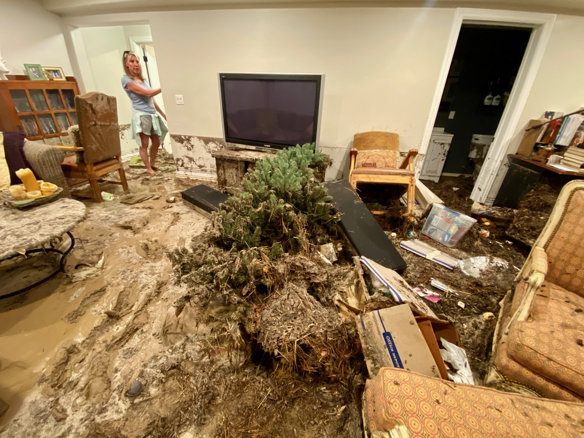 Brenda Taylor stands in the flooded home of a friend's basement in Draper on Friday.