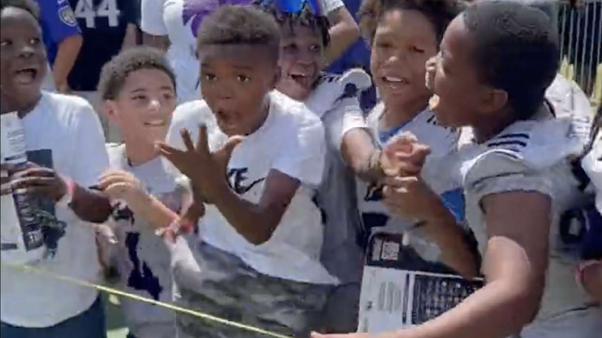 A group of young Baltimore Ravens fans celebrate after getting to high-five quarterback Lamar Jackson.