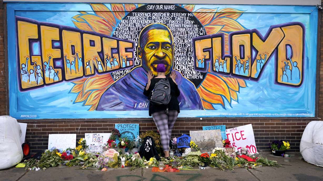 Damarra Atkins pays respect to George Floyd at a mural at George Floyd Square in Minneapolis, April 23, 2021. Tou Thao, the last former police officer convicted in state court for his role in the killing of George Floyd, has been sentenced to 4 years and 9 months.