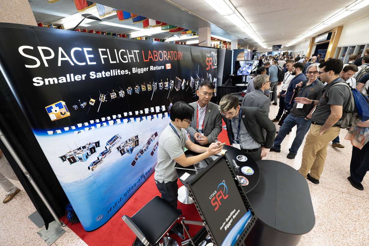 Attendees of the Small Satellite Conference walk around visiting the many booths set up at Utah State University in Logan on Monday.
