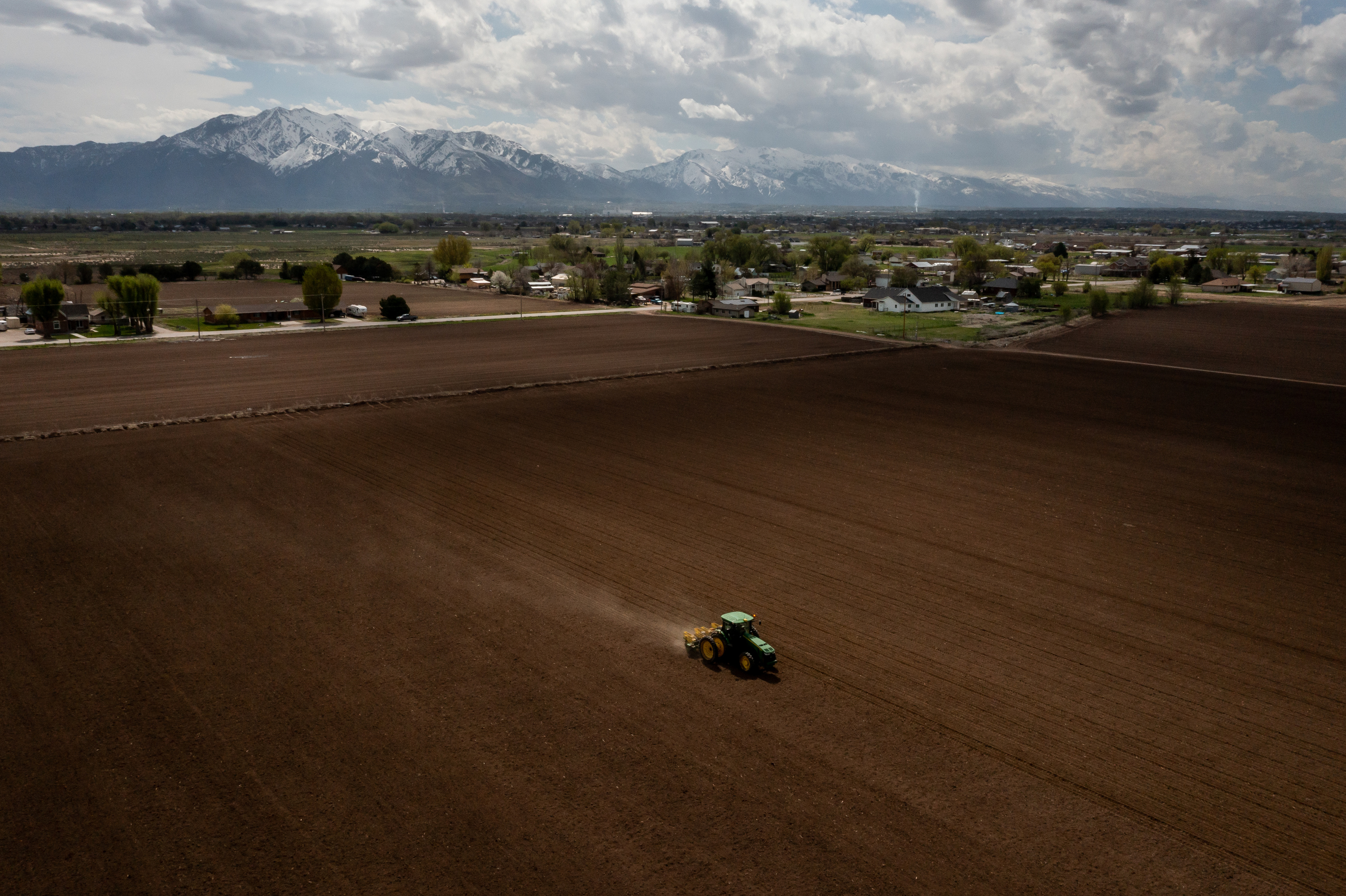 Ron Gibson, owner of Gibson’s Green Acres and president of the Utah Farm Bureau, drives a tractor while planting a field with corn in Ogden on May 4. Utah agriculture officials announced the recipients of 93 water optimization projects on Monday.