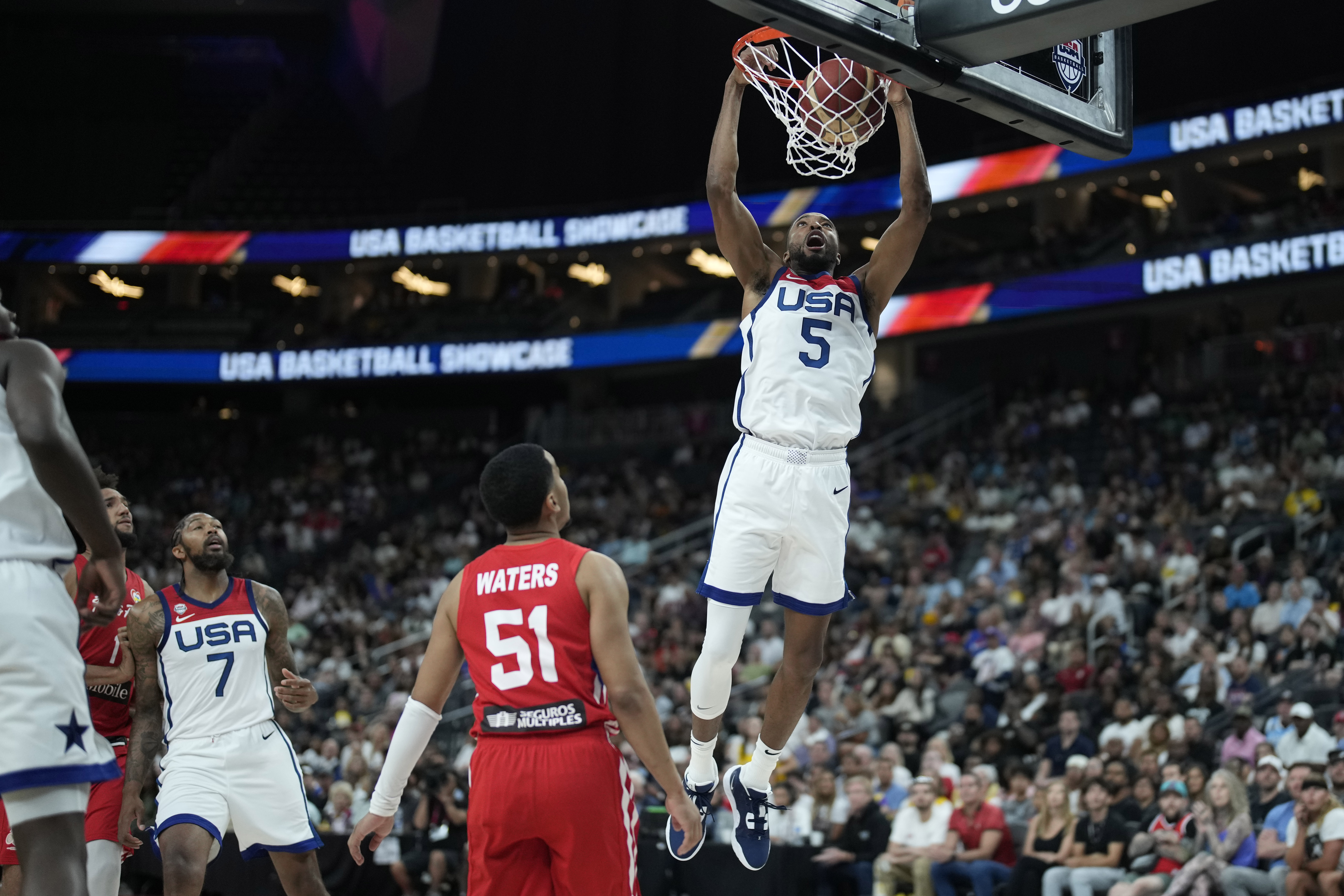 United States' Mikal Bridges (5) dunks over Puerto Rico's Tremont Waters (51) during the first half of an exhibition basketball game Monday, Aug. 7, 2023, in Las Vegas. 