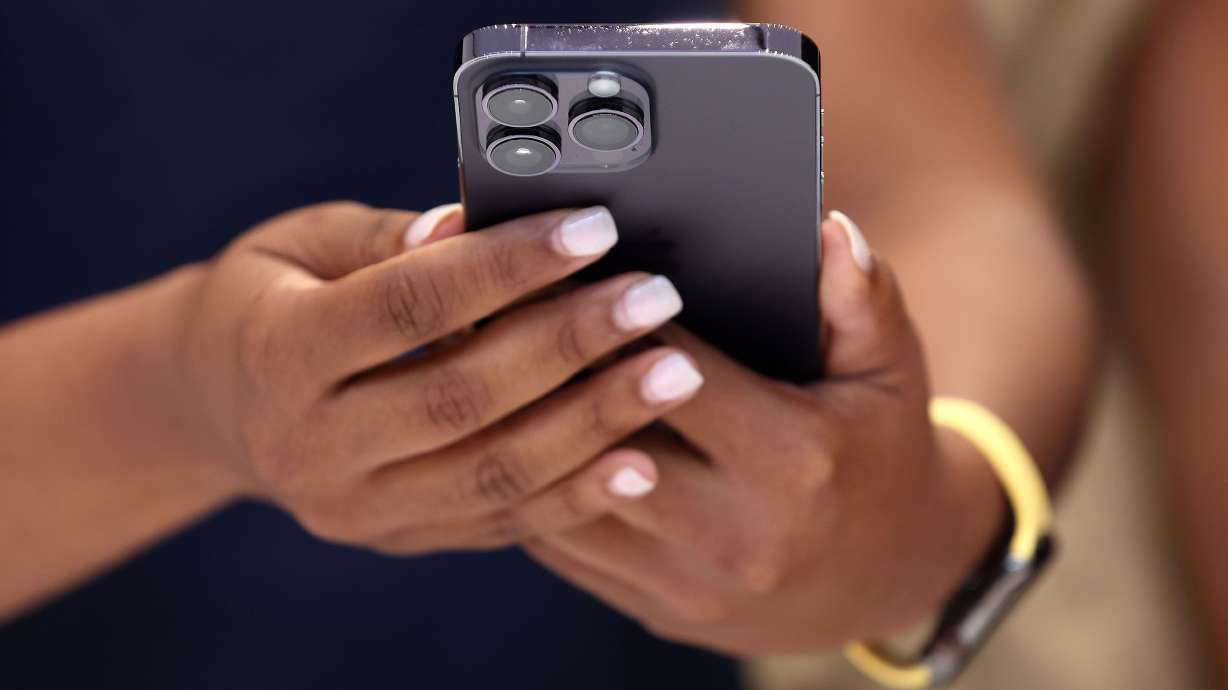 An attendee holds a new Apple iPhone 14 Pro during an Apple special event in Cupertino, California. Apple is making a subtle change to the iPhone's software that will likely mess with your muscle memory.
