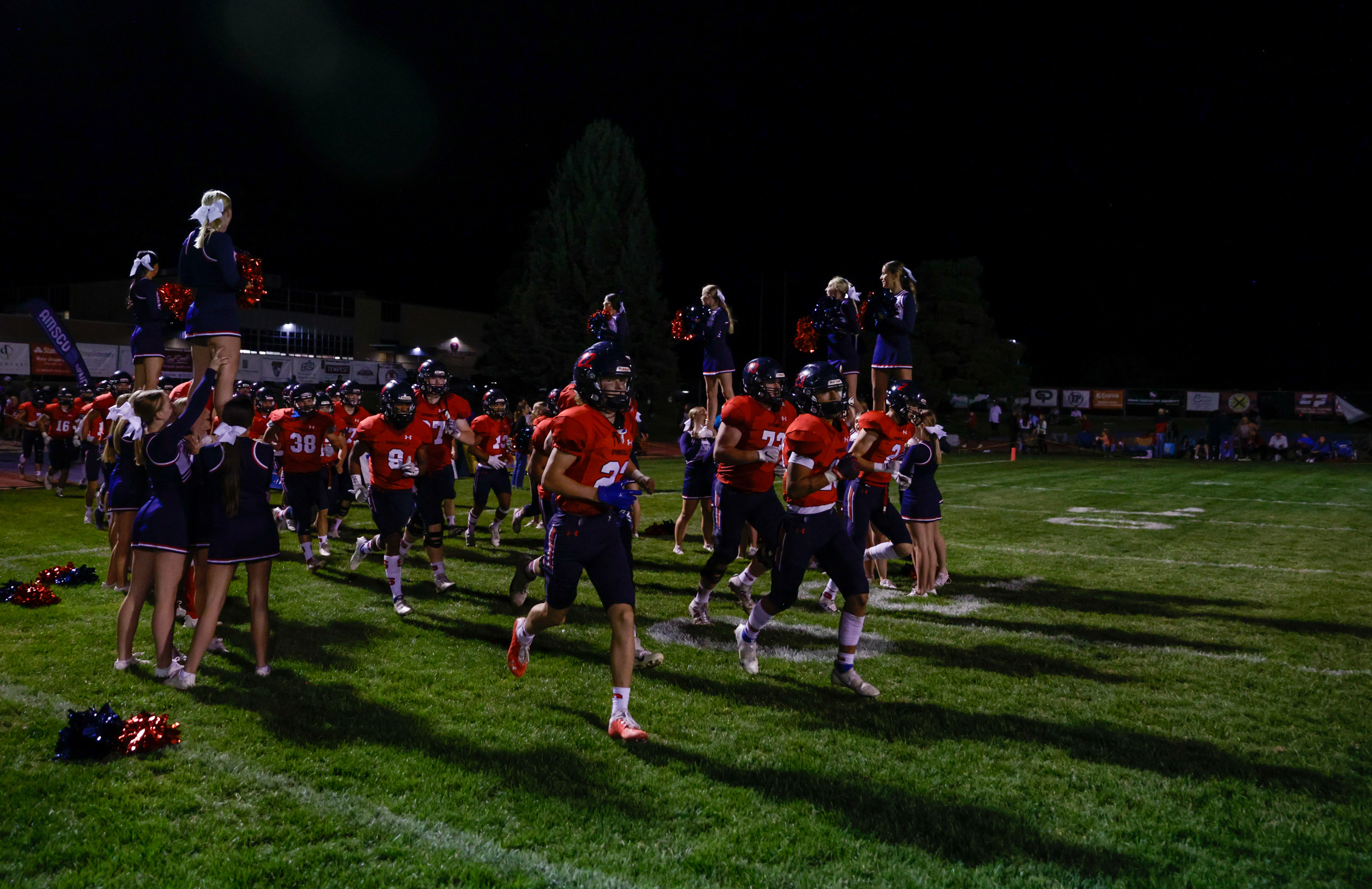 The Springville Red Devils run through cheerleaders after halftime in a football game against the Provo Bulldogs in Springville on Thursday, Sept. 15, 2022. The Red Devils won 18-14.