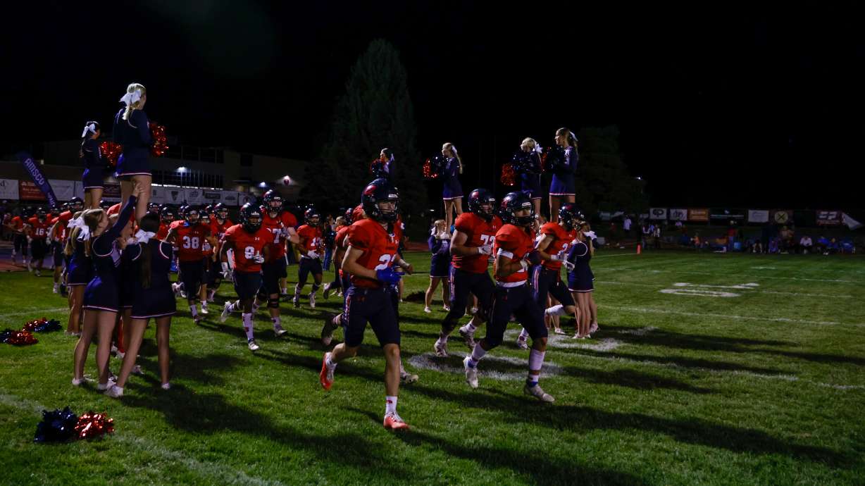 The Springville Red Devils run through cheerleaders after halftime in a football game against the Provo Bulldogs in Springville on Thursday, Sept. 15, 2022. The Red Devils won 18-14.