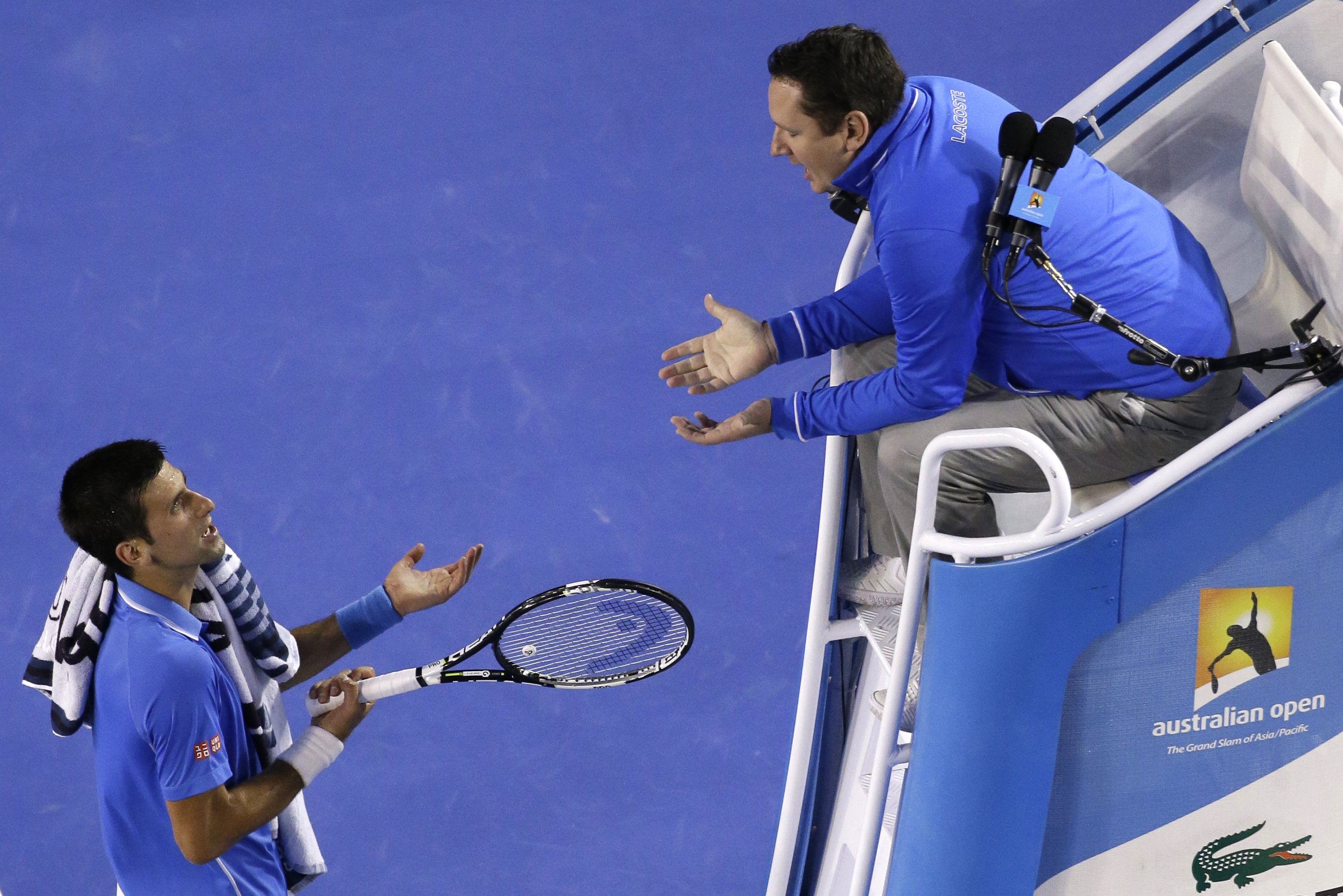 FILE - Novak Djokovic of Serbia, left, talks with chair umpire Jake Garner of the U.S. as he plays Andy Murray of Britain during the men's singles final at the Australian Open tennis championship in Melbourne, Australia, Sunday, Feb. 1, 2015. Video review for double bounces and certain other rulings will be making its Grand Slam tennis debut when main-draw competition begins at the U.S. Open later this month. New U.S. Open tournament referee Jake Garner recalls when he was a chair umpire and it was too tough to tell in the moment whether a ball bounced twice before a player got it back over the net. 