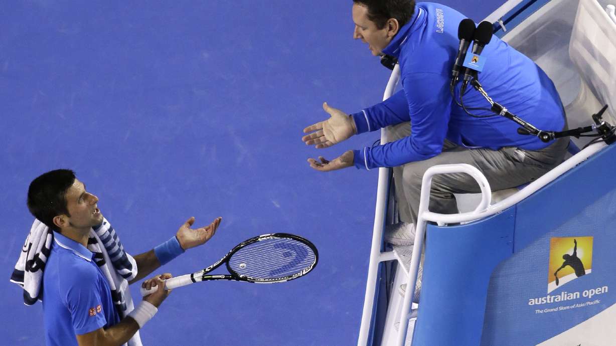 FILE - Novak Djokovic of Serbia, left, talks with chair umpire Jake Garner of the U.S. as he plays Andy Murray of Britain during the men's singles final at the Australian Open tennis championship in Melbourne, Australia, Sunday, Feb. 1, 2015. Video review for double bounces and certain other rulings will be making its Grand Slam tennis debut when main-draw competition begins at the U.S. Open later this month. New U.S. Open tournament referee Jake Garner recalls when he was a chair umpire and it was too tough to tell in the moment whether a ball bounced twice before a player got it back over the net.