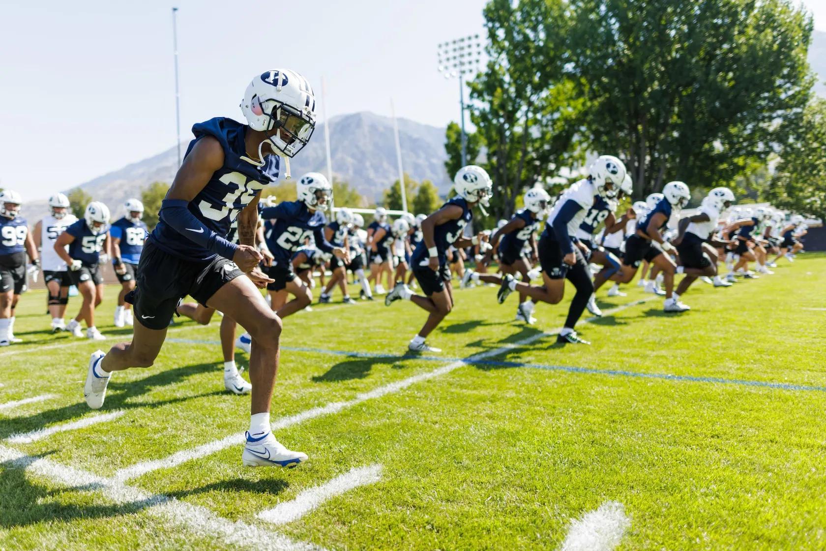 BYU players run through drills during the first week of fall camp at the BYU in Provo. It is the job of Josh Hewitt, BYU’s director of football equipment, to make sure all players have the proper shoes to run through said drills.