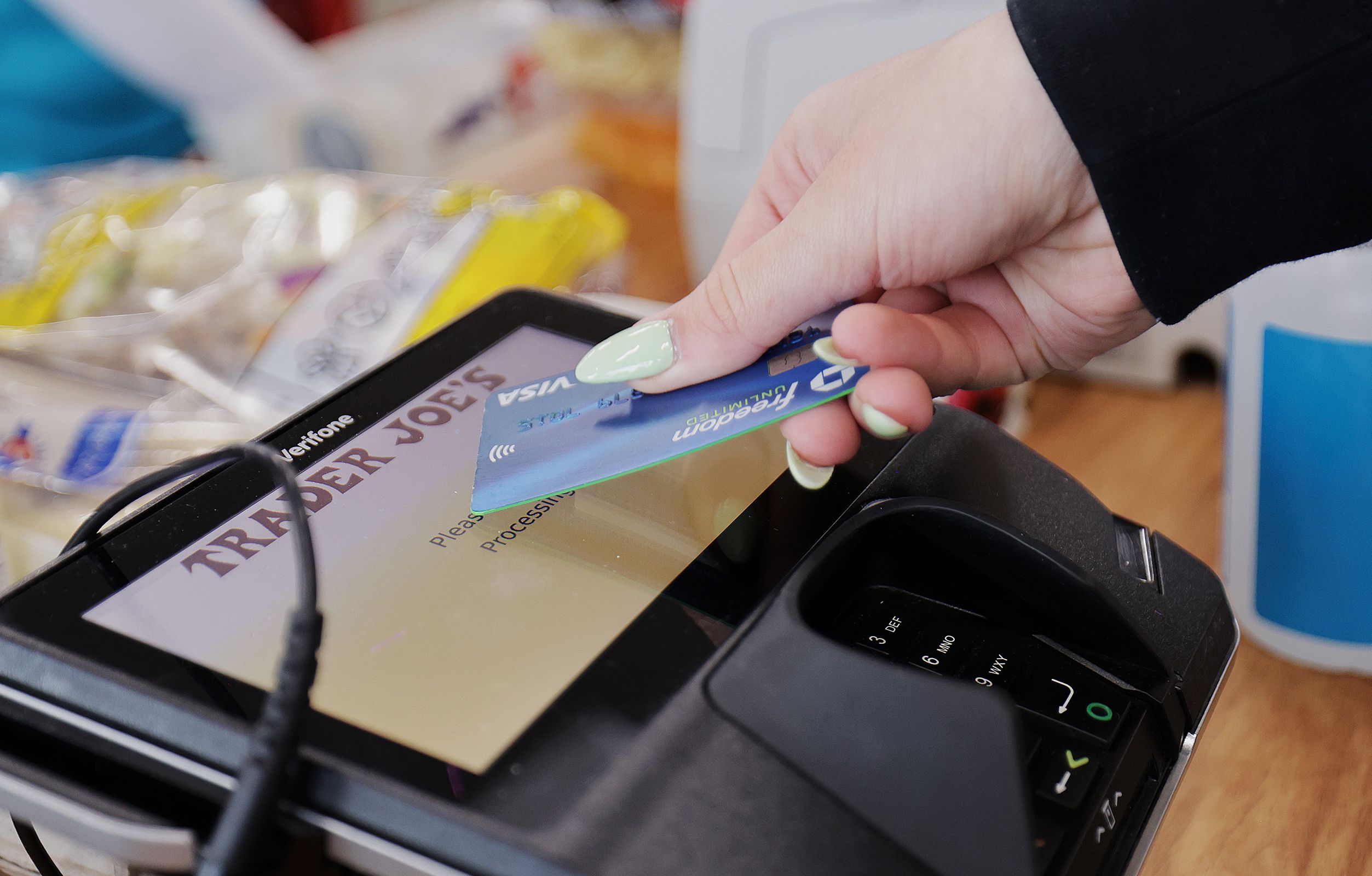 A woman uses her card to make her purchase at Trader Joe’s in Draper on March 3. U.S. consumer credit card debt rose nearly 5% in the second quarter of 2023.