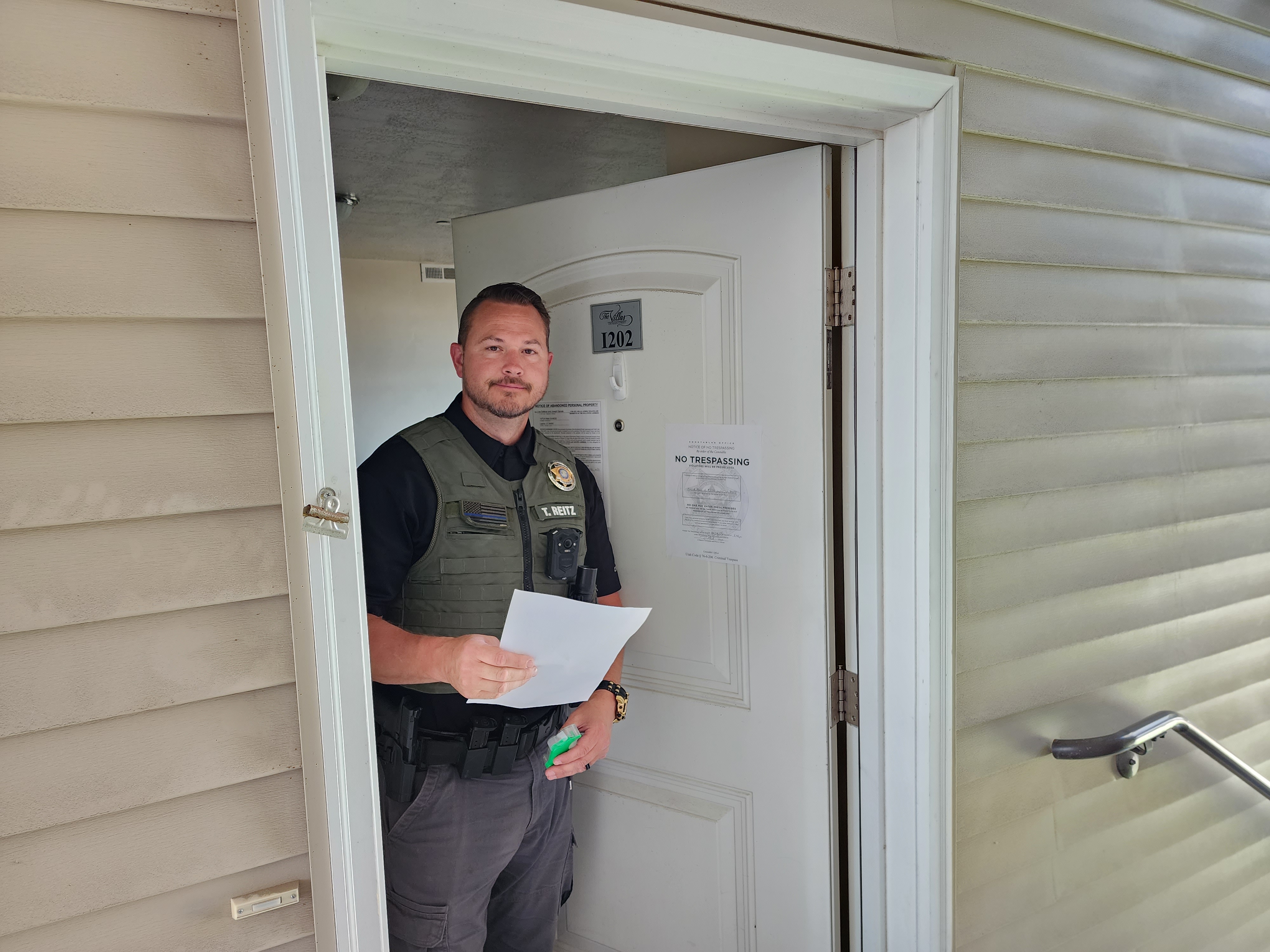 Constable Travis Reitz places orders of eviction and a "no trespassing" notice on an apartment door following an eviction in Salt Lake County in late July.
