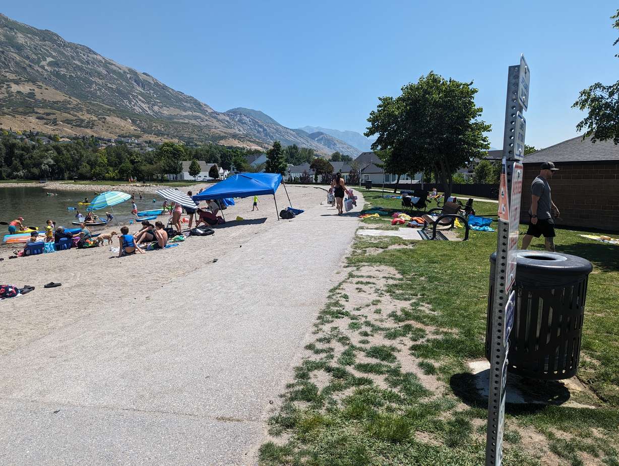 It’s hard to spot the E. coli warning sign, which is posted on the back of other signs at Manila Creek Pond in Pleasant Grove. Families say poor signage is not giving swimmers the warning that a health advisory has been issued for the pond.