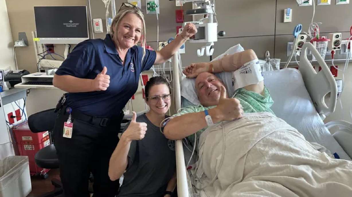 Ron Baker of Bothell, Washington, smiles from his hospital bed next to two nurses at the Utah Valley Hospital after he experienced a heart attack in Delta on June 19. Baker has organized a fundraiser to provide rural communities with better medical equipment that will help them help others.