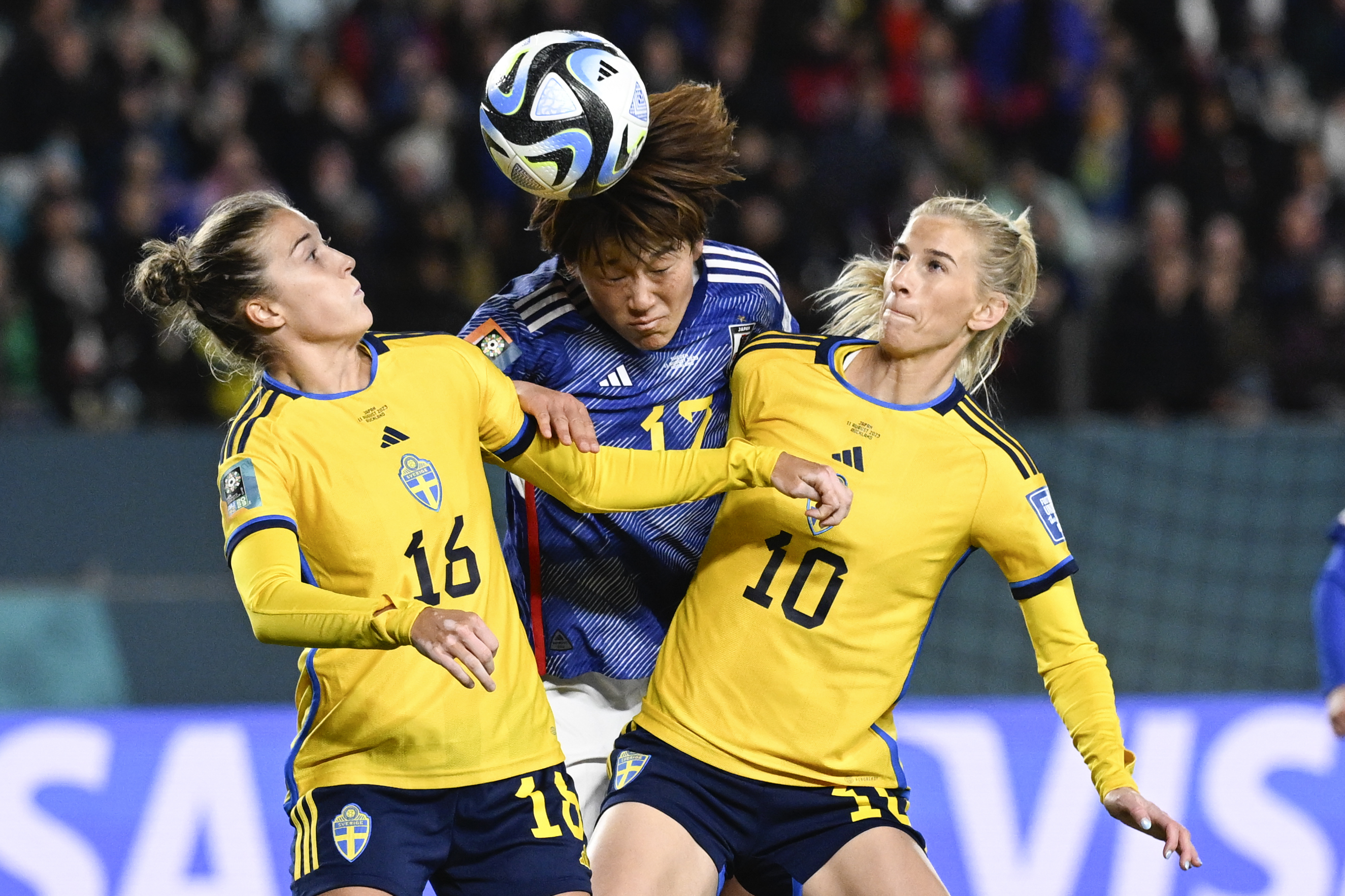 Japan's Hana Takahashi, centre, attempts to head the ball as Sweden's Filippa Angeldal, left, and Sofia Jakobsson, right, compete during the Women's World Cup quarterfinal soccer match between Japan and Sweden at Eden Park in Auckland, New Zealand, Friday, Aug. 11, 2023. 