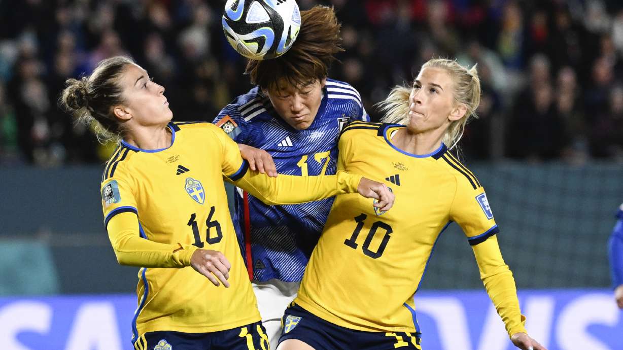Japan's Hana Takahashi, centre, attempts to head the ball as Sweden's Filippa Angeldal, left, and Sofia Jakobsson, right, compete during the Women's World Cup quarterfinal soccer match between Japan and Sweden at Eden Park in Auckland, New Zealand, Friday, Aug. 11, 2023.