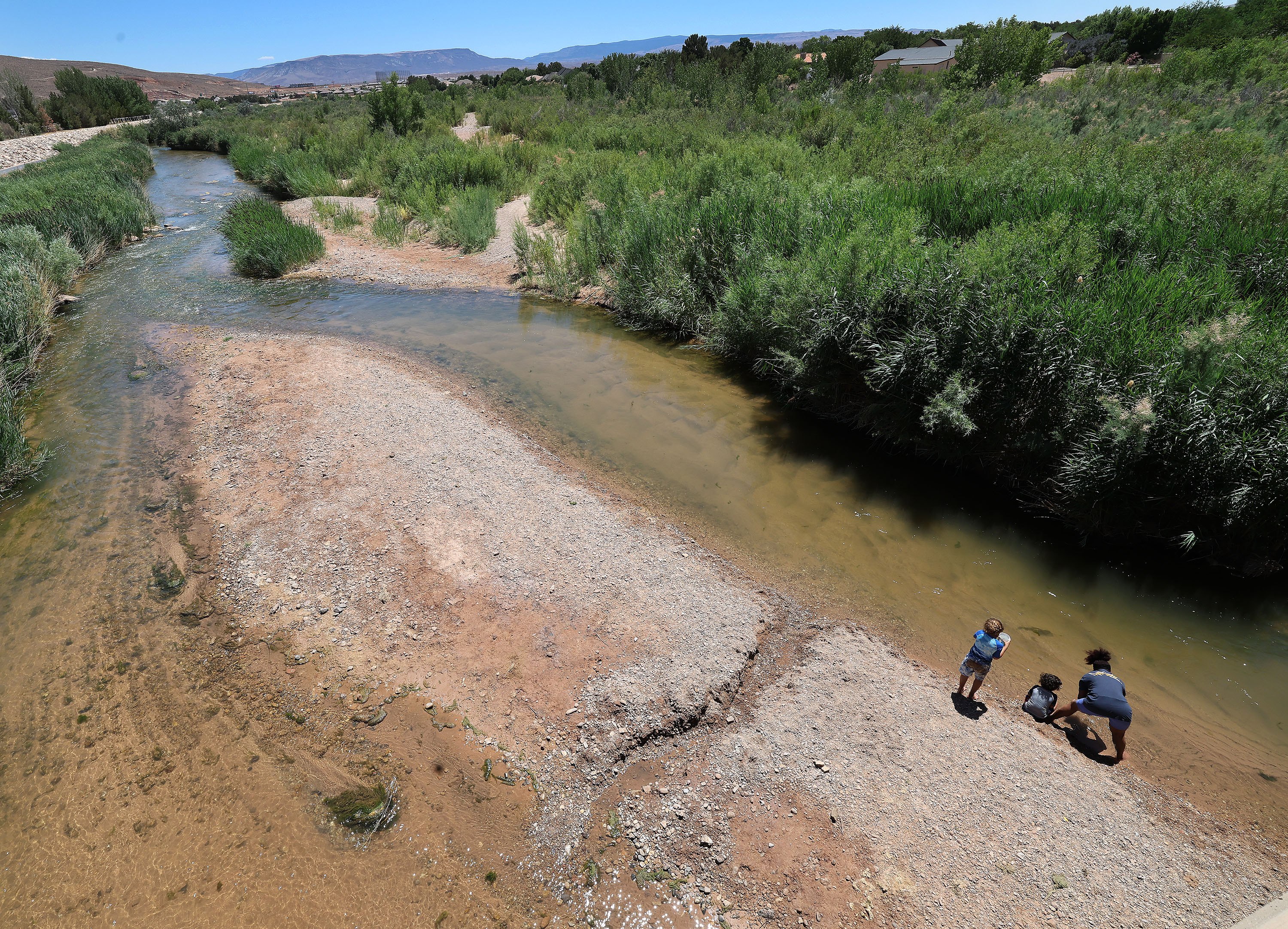 A woman and her children play in the Virgin River on June 10, 2022. The Washington County Water Conservancy District recently published a 20-year plan to guide the county's water use.