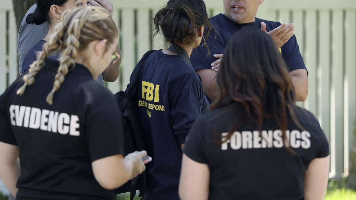 Agents investigate at the residence of Craig Robertson who was shot and killed by FBI agents in Provo on Wednesday. Officials say Robertson posted threatening comments about President Joe Biden hours before the president visited Utah.