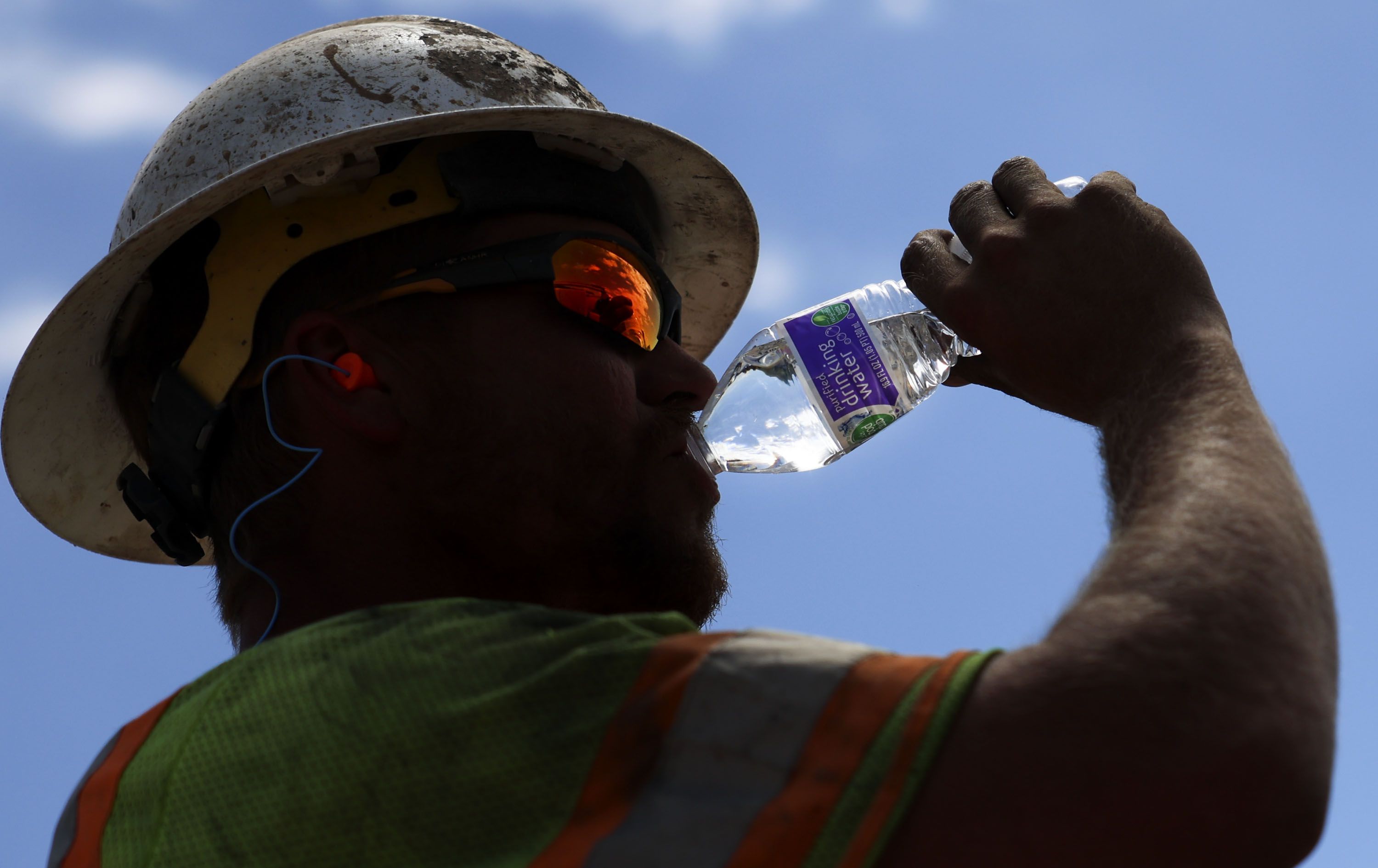 Garrett Rowser hydrates while working on the I-215 renewed reconstruction project in Salt Lake City on Friday.