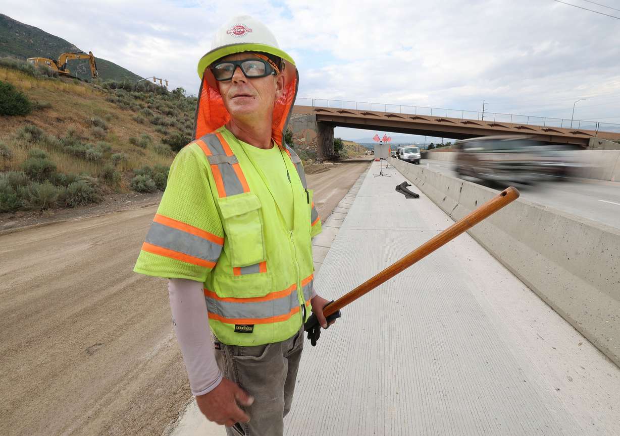 Steve Hardy works on I-215 in Millcreek on Aug. 1. The heat wave is extreme across much of the country.