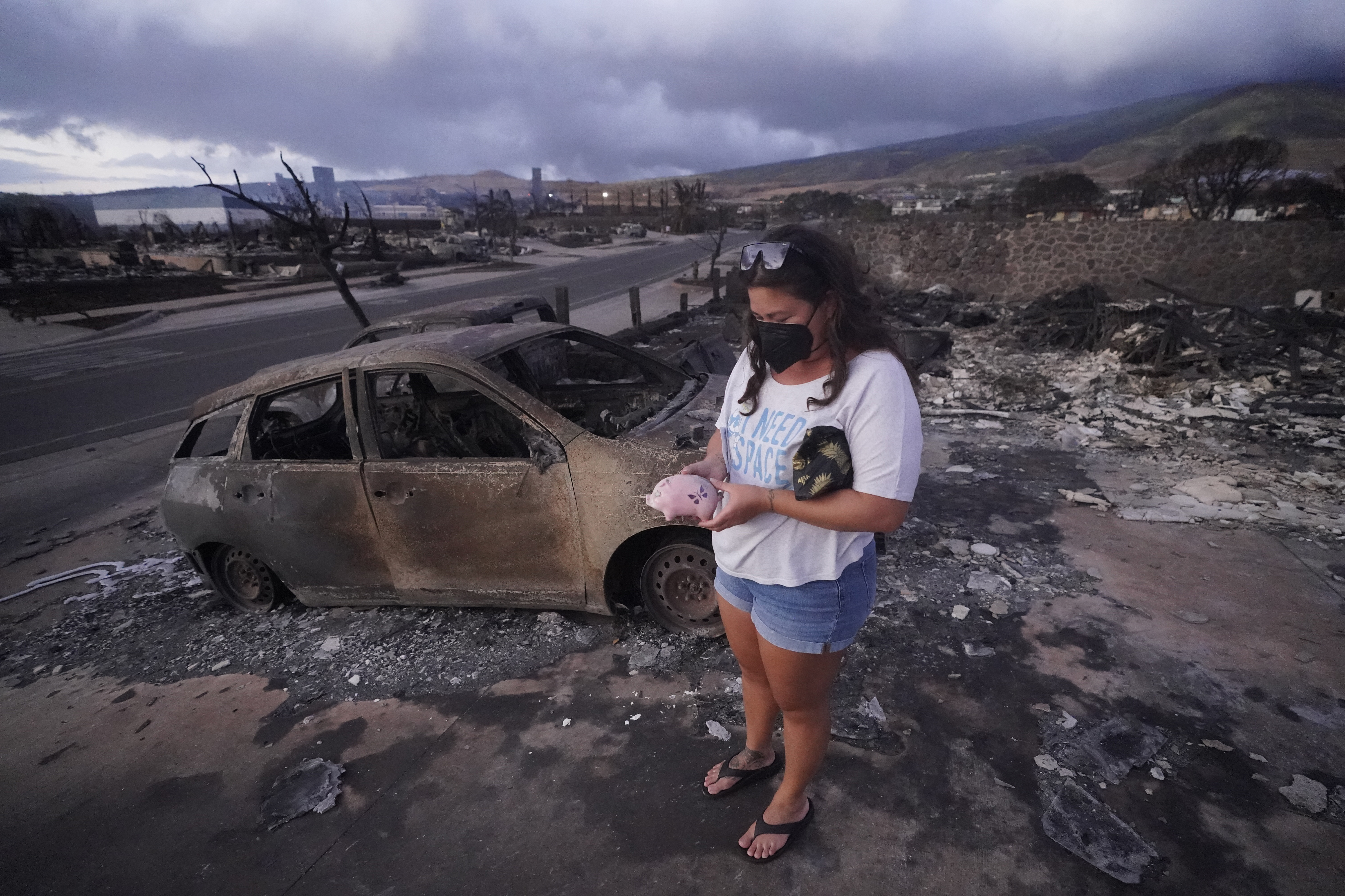Summer Gerling stands in the rubble following the wildfire Thursday, in Lahaina, Hawaii. Emergency management records show no indication that warning sirens sounded before people ran for their lives from wildfires on Maui that wiped out a historic town.