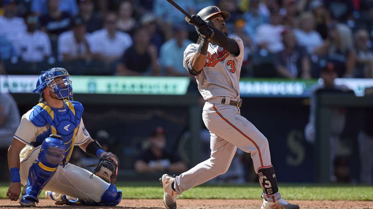 Baltimore Orioles' Cedric Mullins , right, watches the flight of his two-run home run against the Seattle Mariners during the 10th inning a baseball game, Sunday, Aug. 13, 2023, in Seattle.