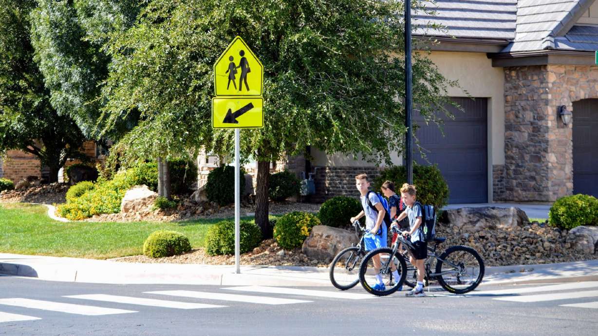 Students with bikes stop at a crosswalk in St. George, Sept. 15, 2022. The new school year renews the need for pedestrians and motorists to pay attention to who is on the road.