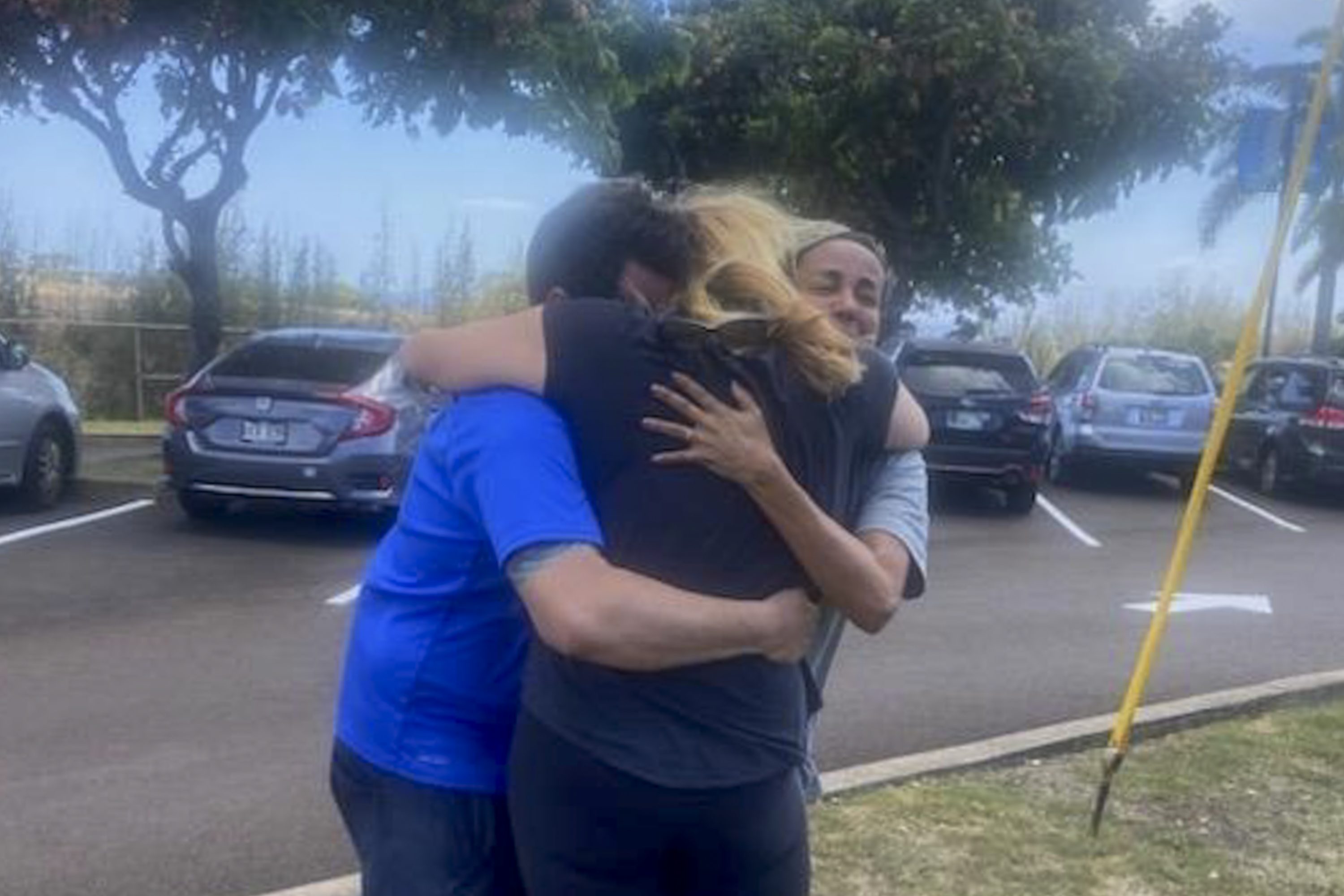 This Aug. 9 photo shows Mike Cicchino, left, and his wife Andreza Cicchino, right, hugs Mike Cicchino's mother Susan Ramos as they were reunited at shelter in Maui, Hawaii. 
