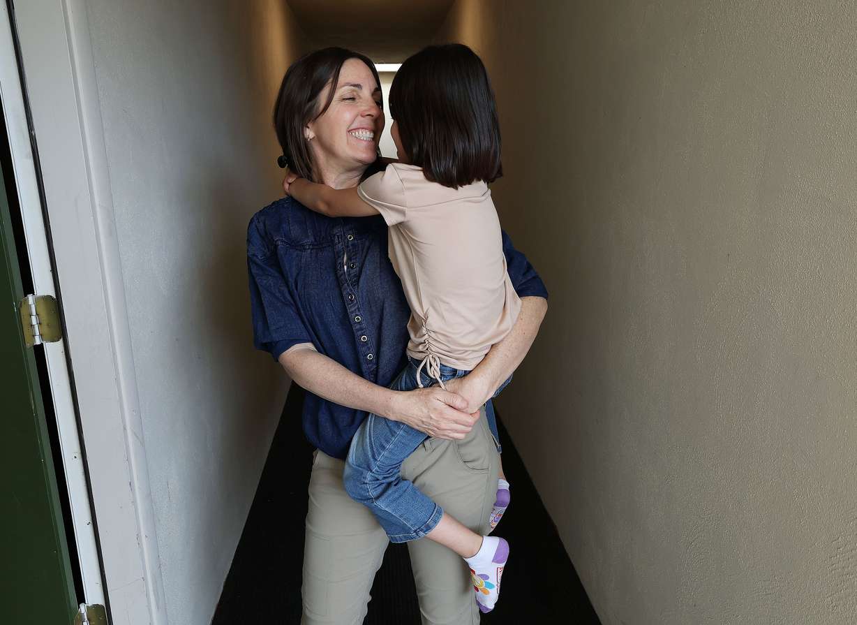 Kerry Wickman talks with a 6-year-old Afghan girl near her apartment in Salt Lake City on July 27. The child's identity is not shown to help protect her family from the Taliban.