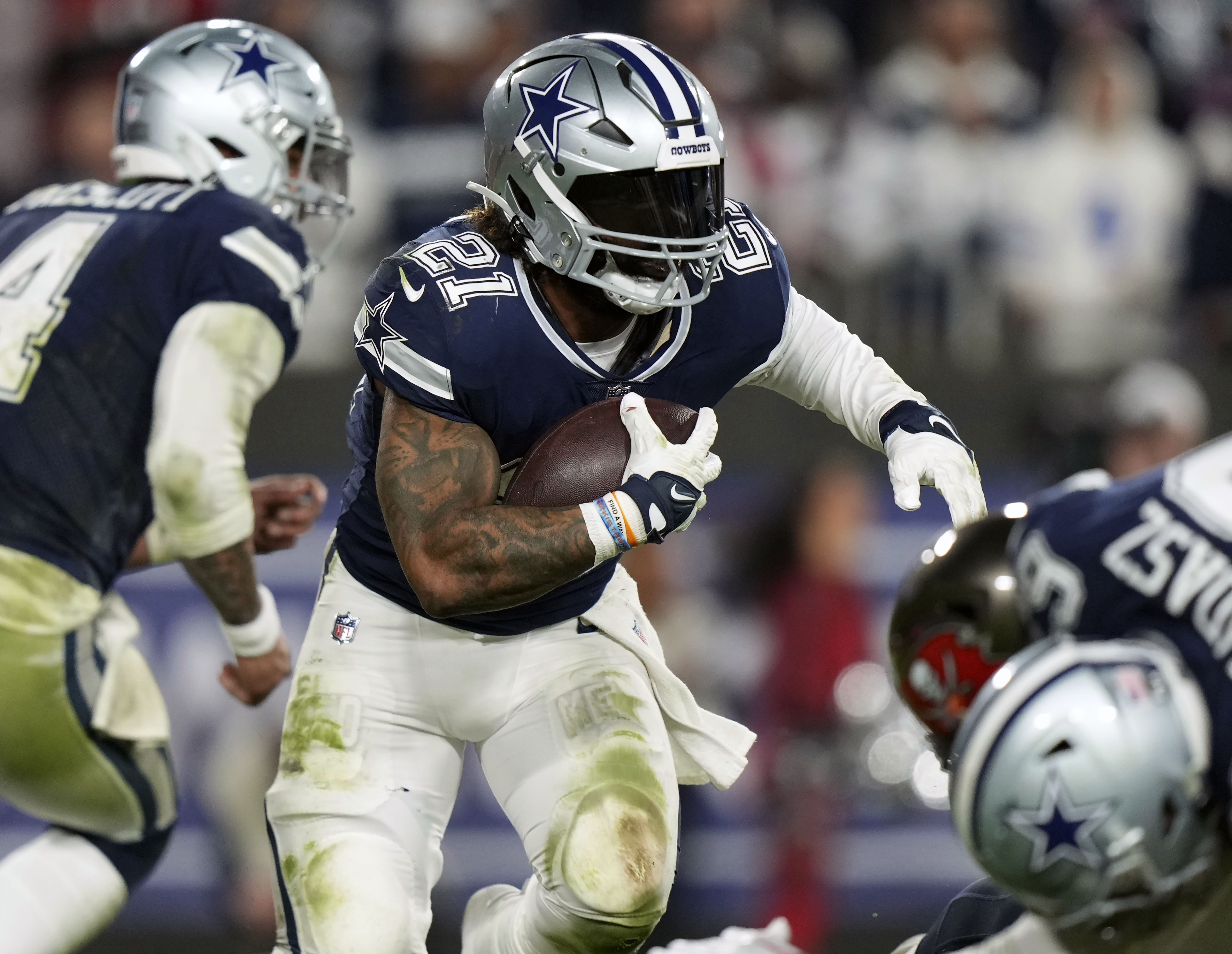 FILE - Dallas Cowboys running back Ezekiel Elliott (21) looks for running room as he rushes with the ball during an NFL wild-card football game against the Tampa Bay Buccaneers, Jan. 16, 2023, in Tampa, Fla. A person familiar with the terms tells The Associated Press that three-time Pro Bowl running back Elliott has signed a one-year deal with the New England Patriots worth $4 million. The person spoke on condition of anonymity because the team has not announced the move. 