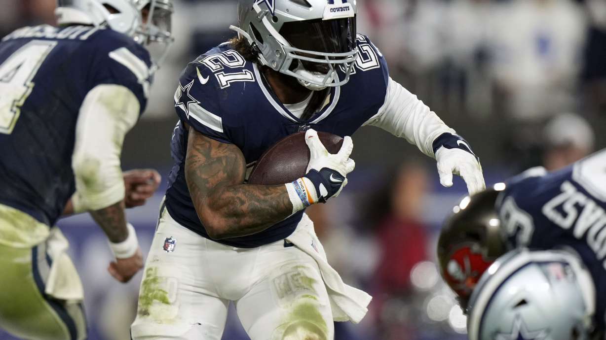 FILE - Dallas Cowboys running back Ezekiel Elliott (21) looks for running room as he rushes with the ball during an NFL wild-card football game against the Tampa Bay Buccaneers, Jan. 16, 2023, in Tampa, Fla. A person familiar with the terms tells The Associated Press that three-time Pro Bowl running back Elliott has signed a one-year deal with the New England Patriots worth $4 million. The person spoke on condition of anonymity because the team has not announced the move.