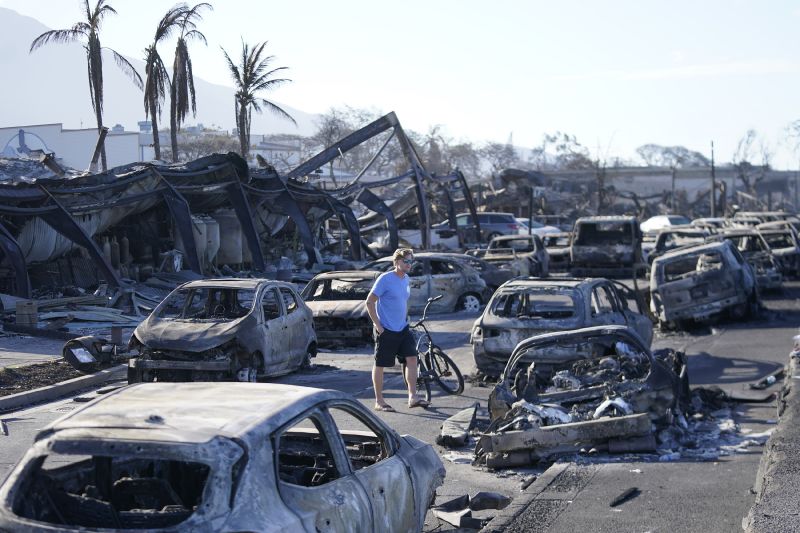 A man walks through wildfire wreckage Aug. 11 in Lahaina, Hawaii. Hawaii emergency management records show no indication that warning sirens sounded before people ran for their lives from wildfires on Maui that wiped out a historic town.