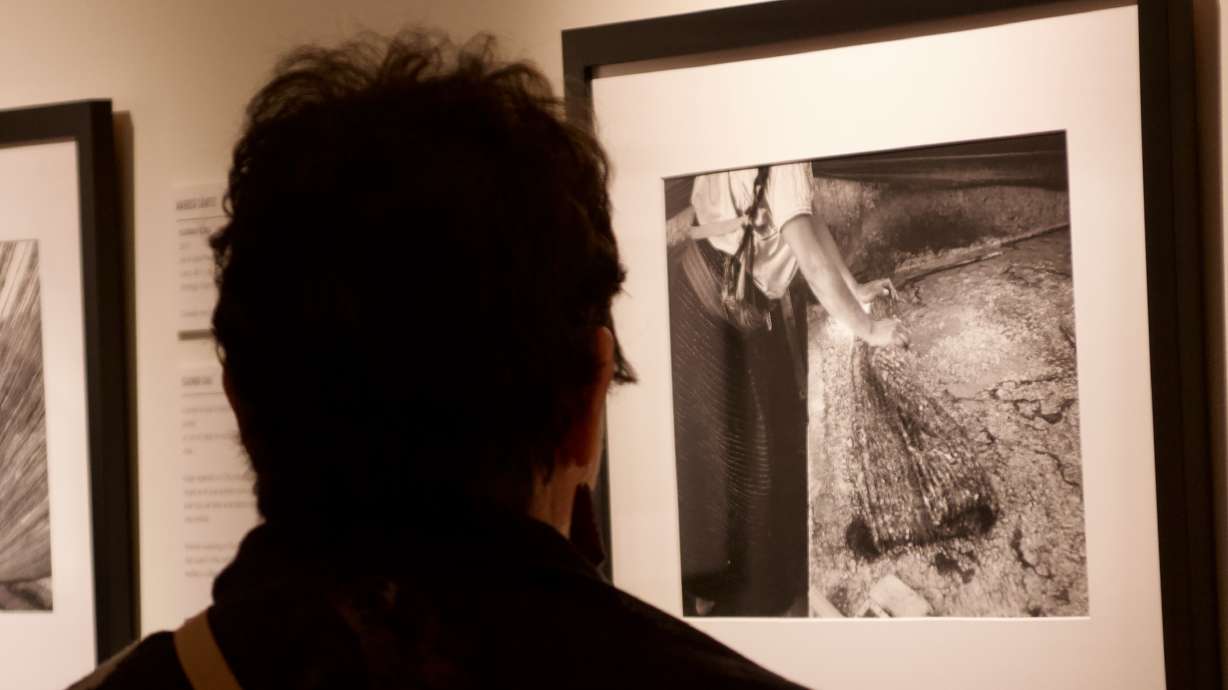 A person looks at a photo and textile exhibit by artist Maruch Santíz Gómez at the Utah Valley University Museum of Art on Aug. 8.