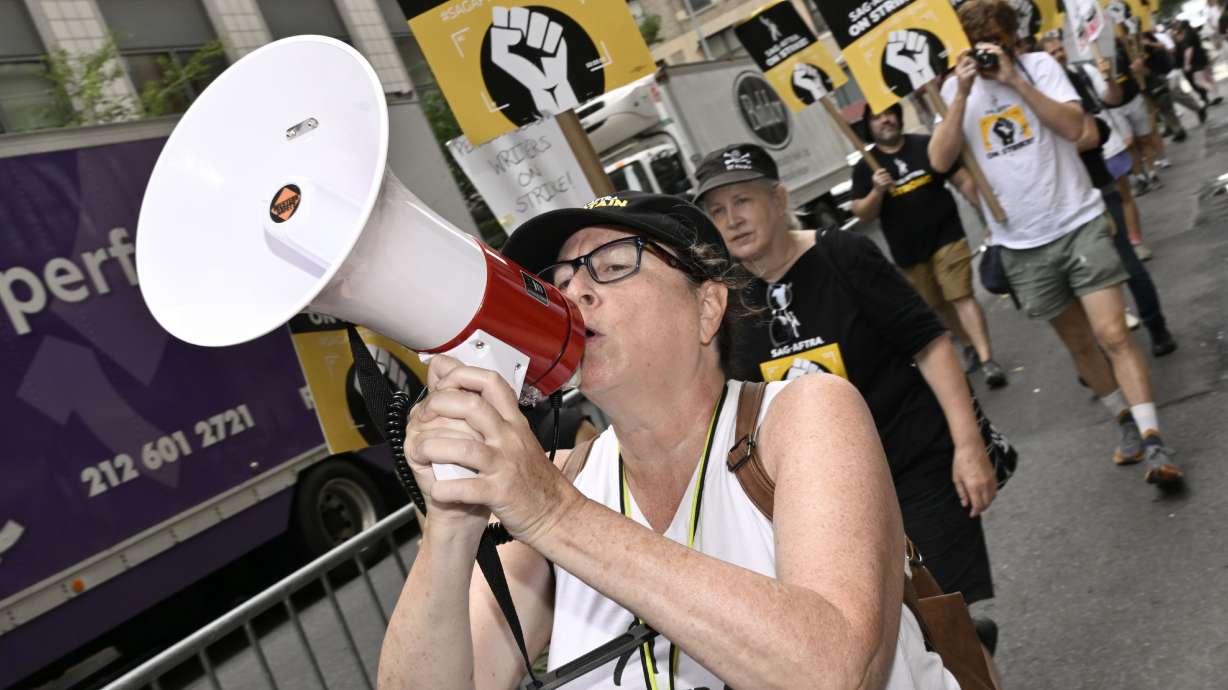 Picketers carry signs on the picket line outside Netflix on Aug. 14 in New York. The actors strike faces the issue of using artificial intelligence, or AI, in the entertainment industry.