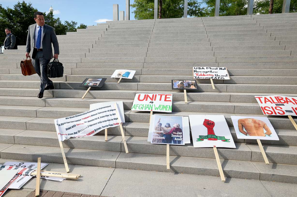 Attorney Rudy Bautista looks at protest signs as he leaves the Orrin G. Hatch U.S. Courthouse in Salt Lake City on the second anniversary of the Taliban takeover in Afghanistan on Tuesday.