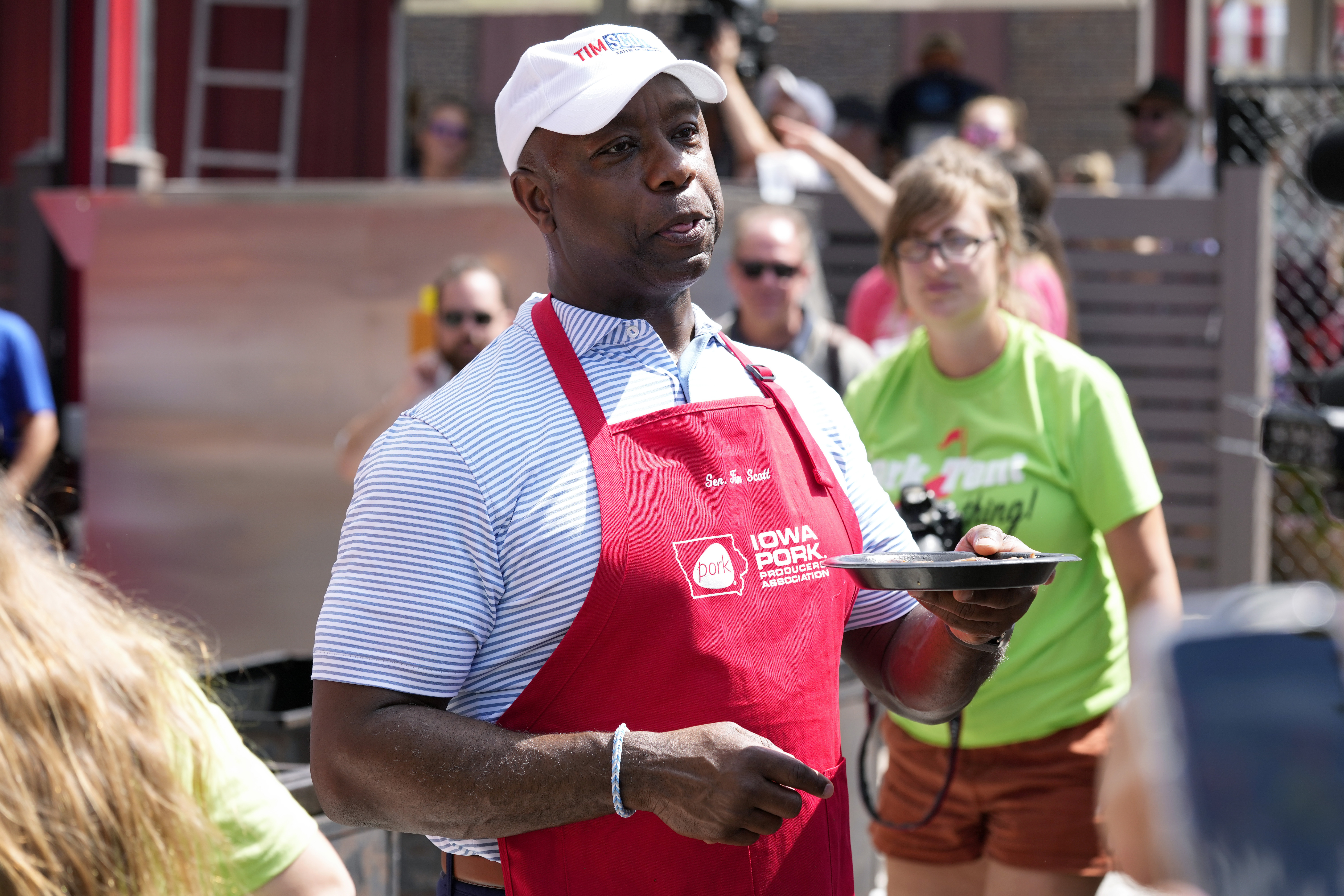 Republican presidential candidate Sen. Tim Scott, R-S.C., serves pork samples after working the grill at the Iowa Pork Producers tent at the Iowa State Fair Aug. 15 in Des Moines, Iowa. 