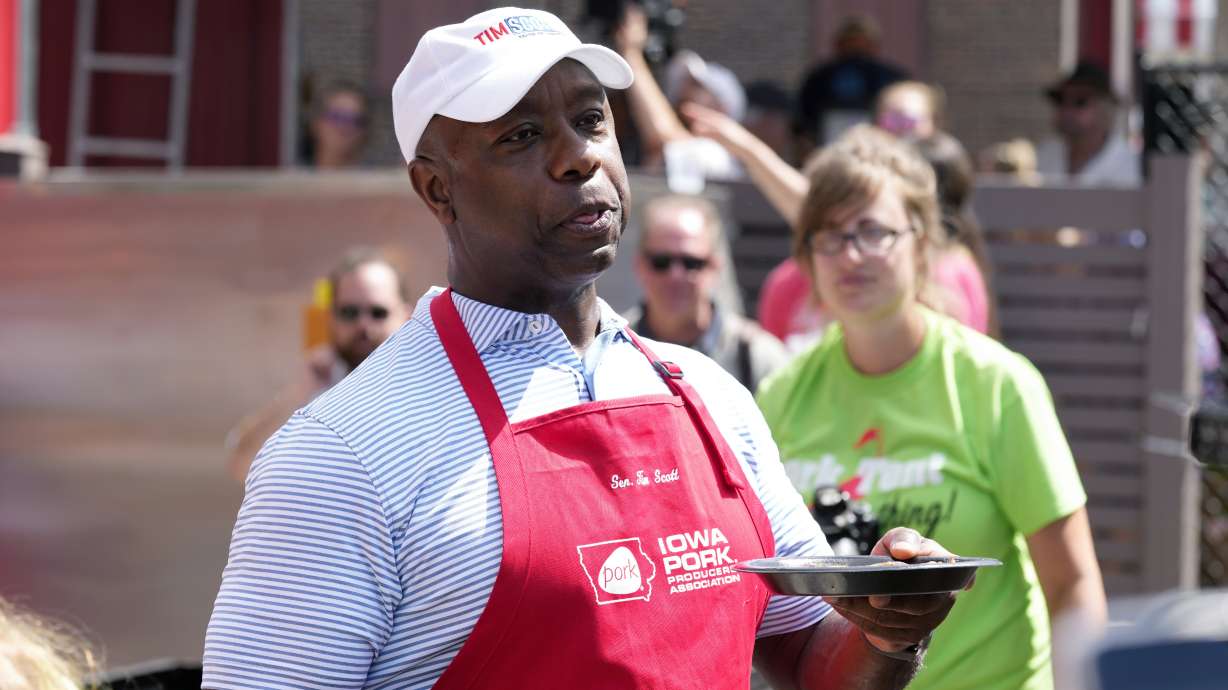 Republican presidential candidate Sen. Tim Scott, R-S.C., serves pork samples after working the grill at the Iowa Pork Producers tent at the Iowa State Fair Aug. 15 in Des Moines, Iowa.