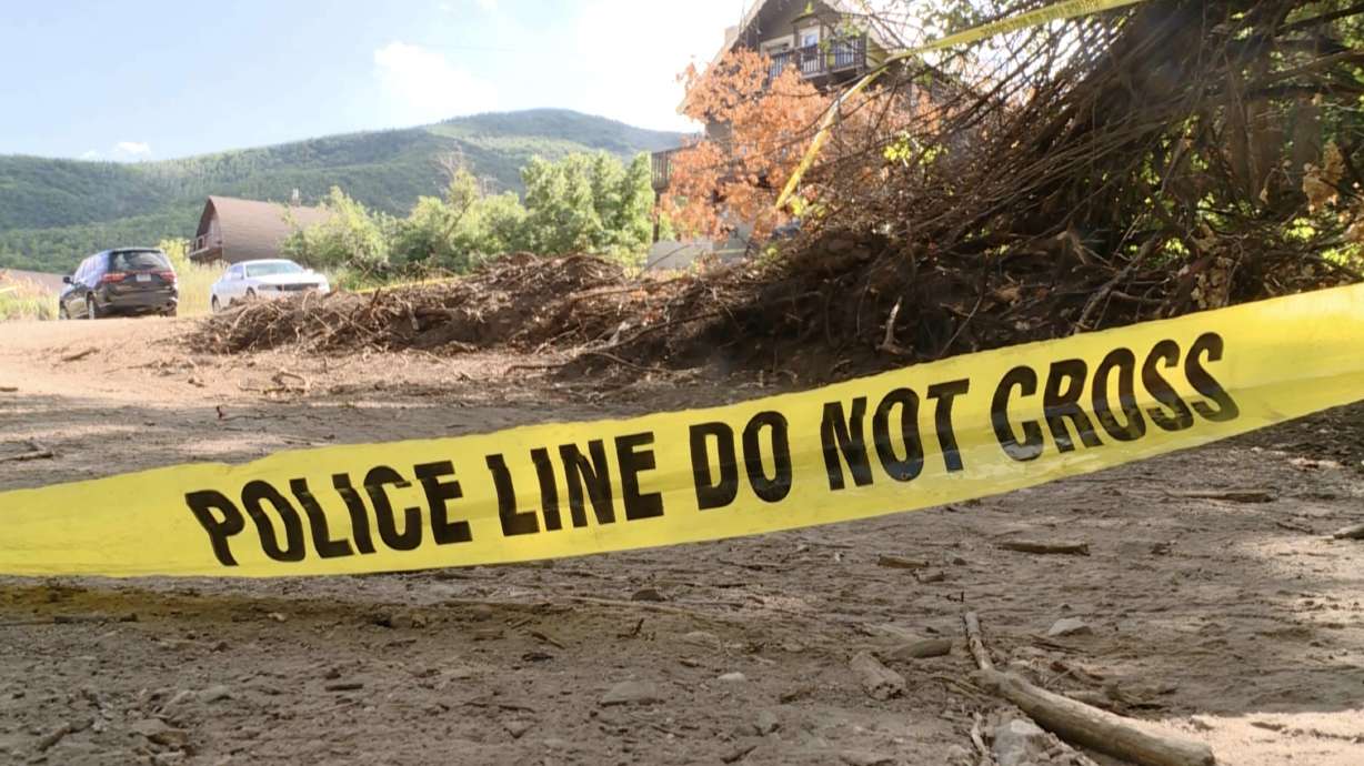 Police tape drapes the property surrounding a Wasatch County cabin on Aug. 8, a day after police say one man was killed and another received critical injuries from a shooting and stabbing incident at the cabin.