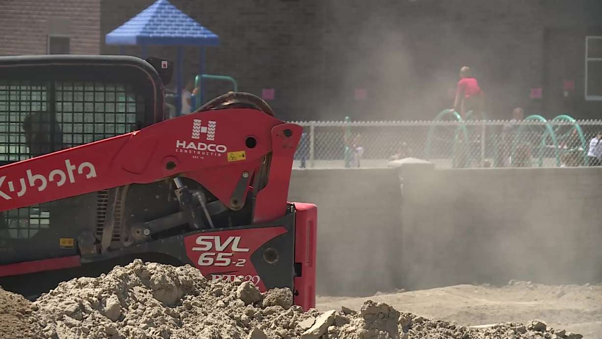 Construction workers are outside the school grounds as kids play. It was a race to the finish line to complete a new elementary school in the Overland community in time for the first day of class.