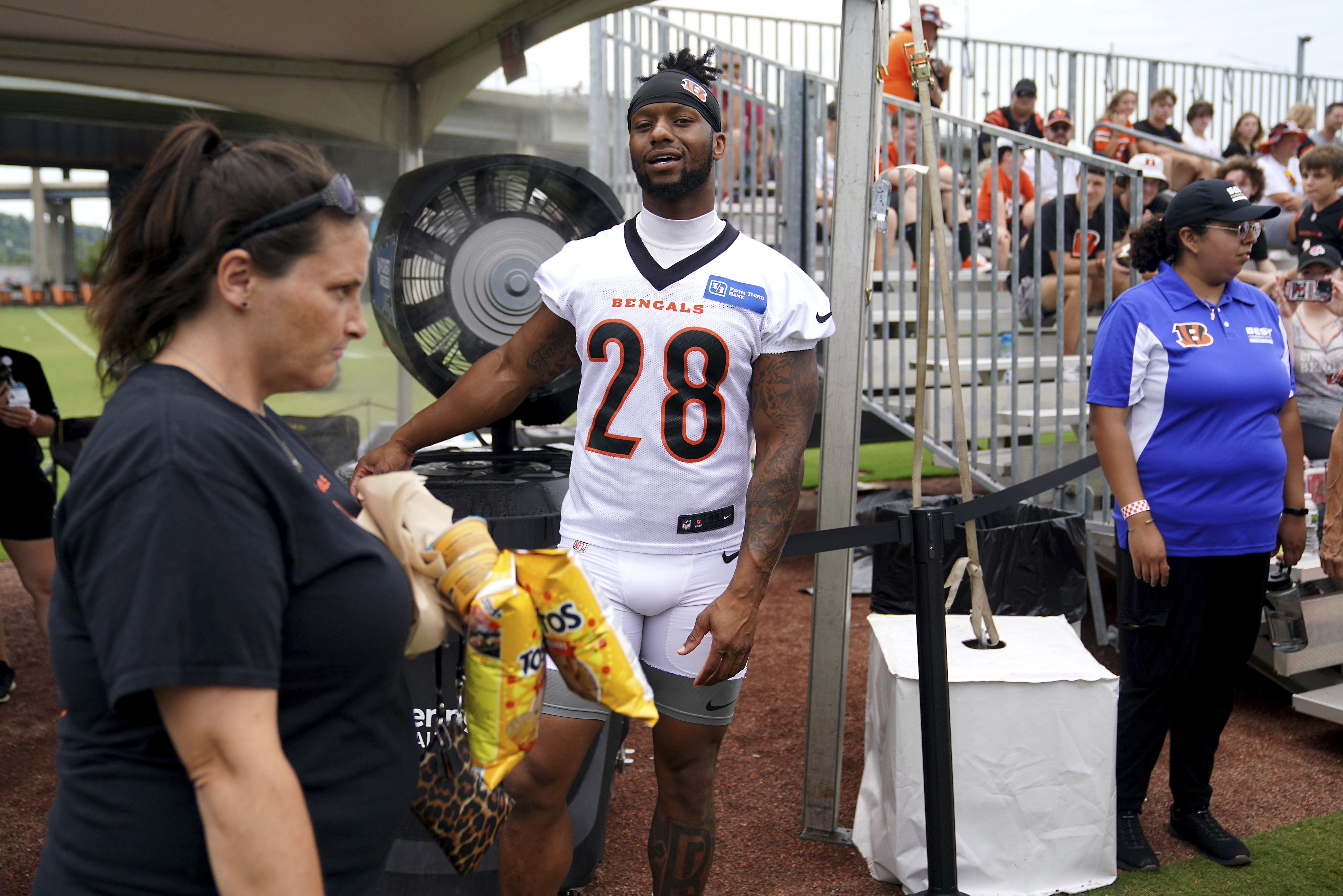 Cincinnati Bengals running back Joe Mixon (28) stays cool in front a water-misting fan in the fan section during the NFL football team's training camp Friday, July 28, 2023, in Cincinnati.