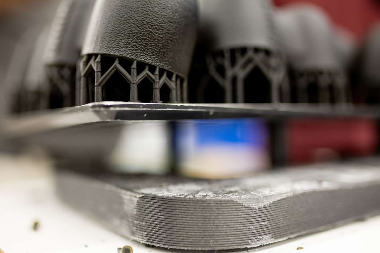 Parts that were printed using additive manufacturing techniques await finishing at Merit3D in Price on Thursday.