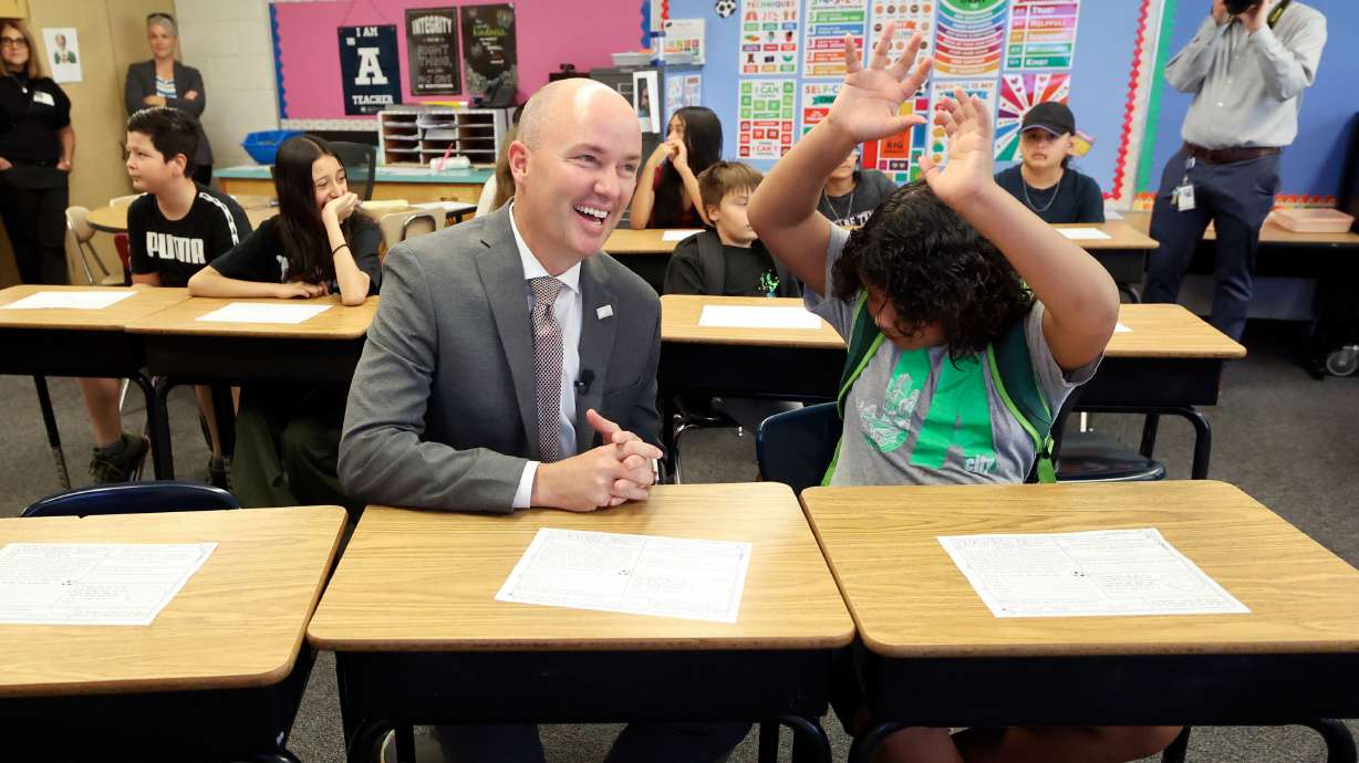 Utah Gov. Spencer Cox sits next to sixth grader Kevon Milo while visiting Magna Elementary School in Magna on Friday.