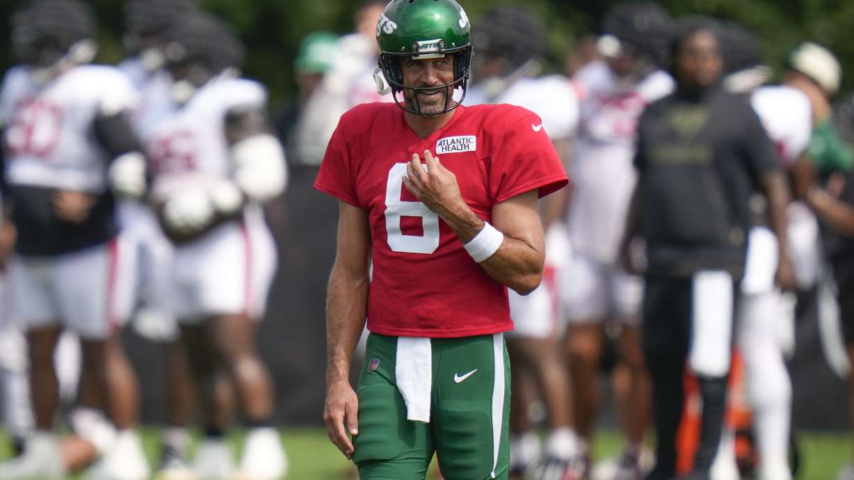 New York Jets quarterback Aaron Rodgers smiles during a joint NFL football practice with the Tampa Bay Buccaneers, Wednesday, Aug. 16, 2023, in Florham Park, N.J.