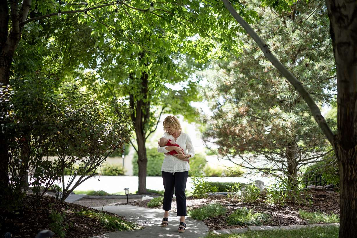 Cindy Davis walks through her backyard with her 9-week-old granddaughter Indy while babysitting her at home in Cedar Hills on Tuesday. Grandparenting can boost grandkids’ sense of security and help grandparents live happier and longer lives, experts say.
