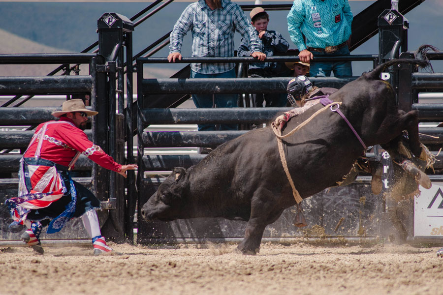 Michael Francis fighting off a bull as his son fights to rack up competition points.