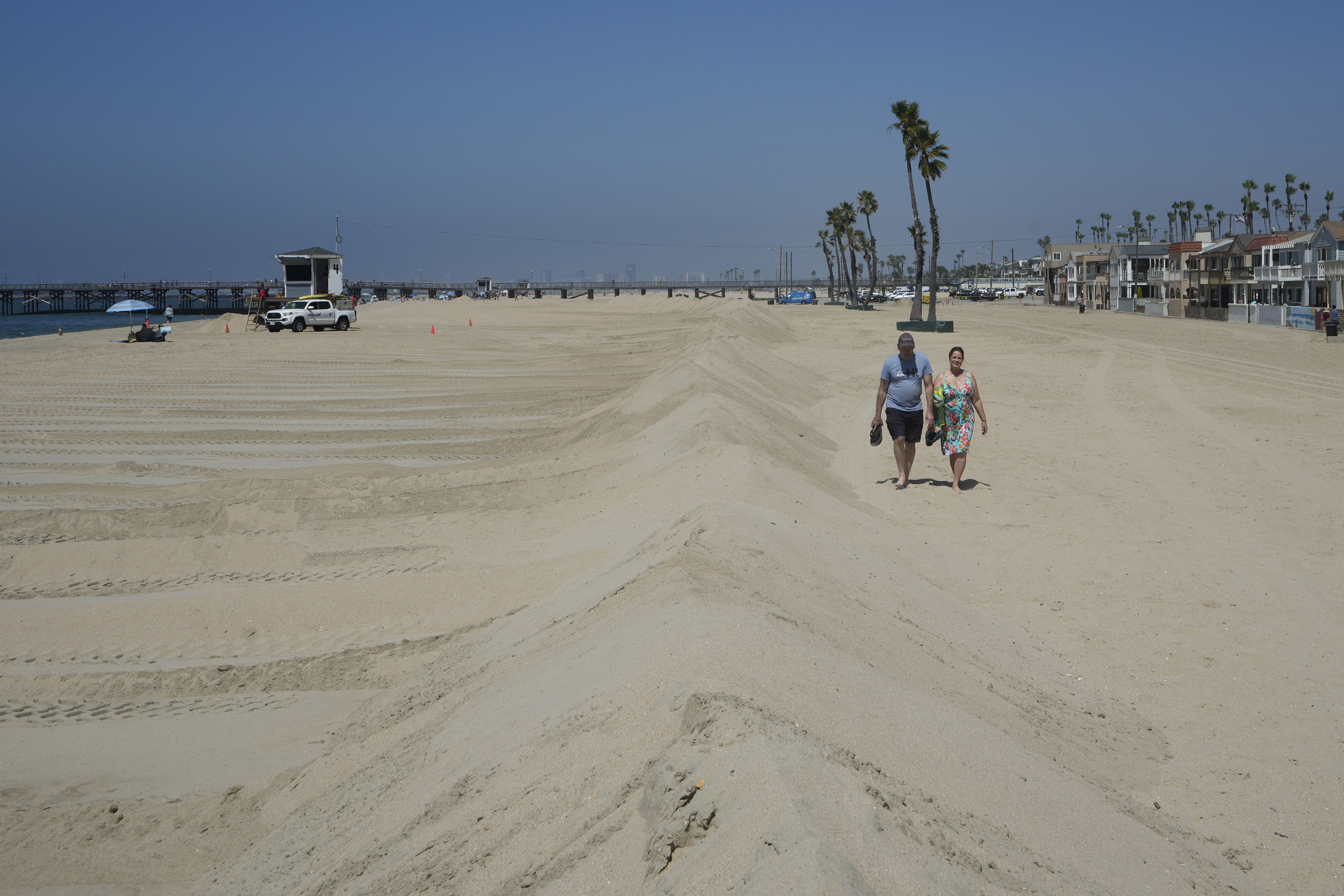 A couple walks along berms in Seal Beach, Calif., Friday. Officials in Southern California were also re-enforcing sand berms, built to protect low-lying coastal communities against winter surf.