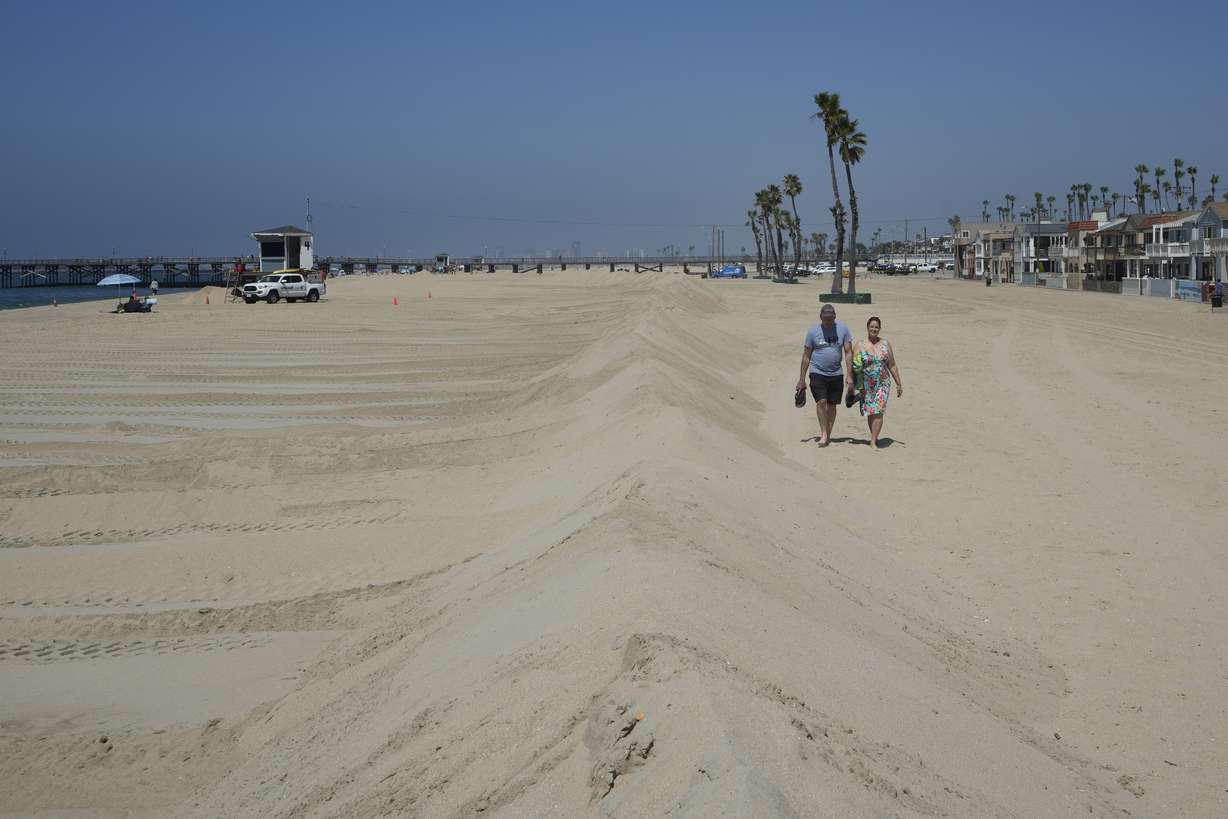 A couple walks along berms in Seal Beach, Calif., Friday. Officials in Southern California were also re-enforcing sand berms, built to protect low-lying coastal communities against winter surf.
