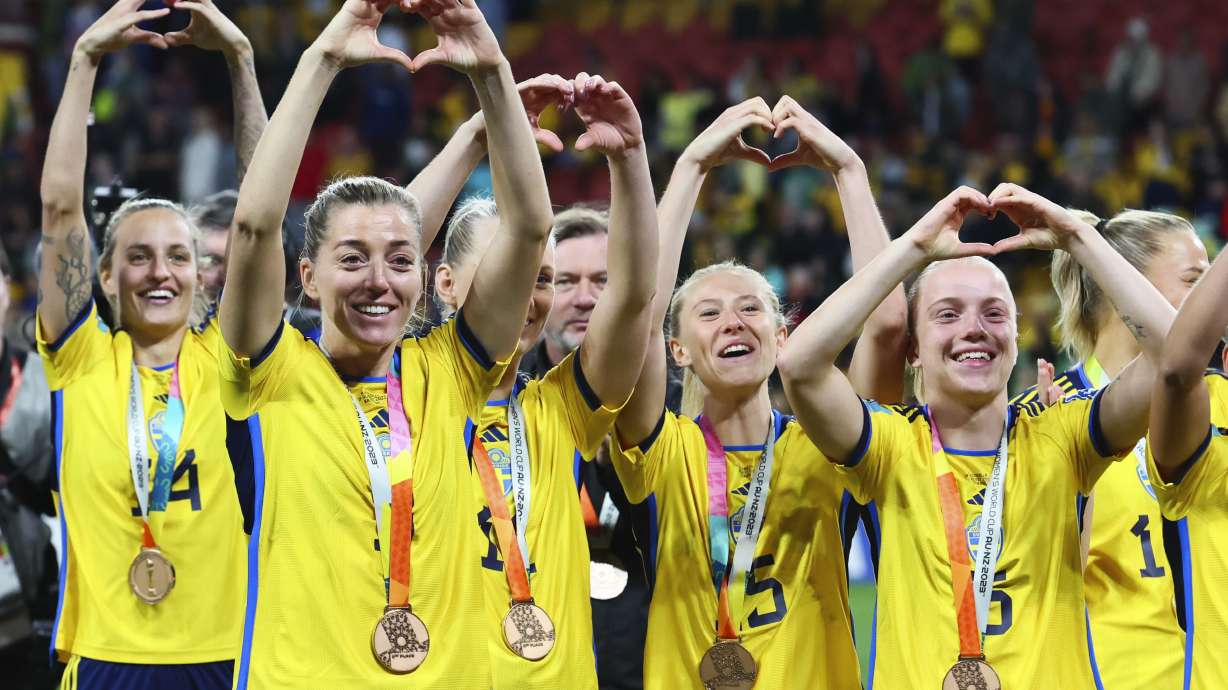 Sweden gesture to supporters as they celebrate with their bronze medals after defeating Australia in the Women's World Cup third place playoff soccer match in Brisbane, Australia, Saturday, Aug. 19, 2023.