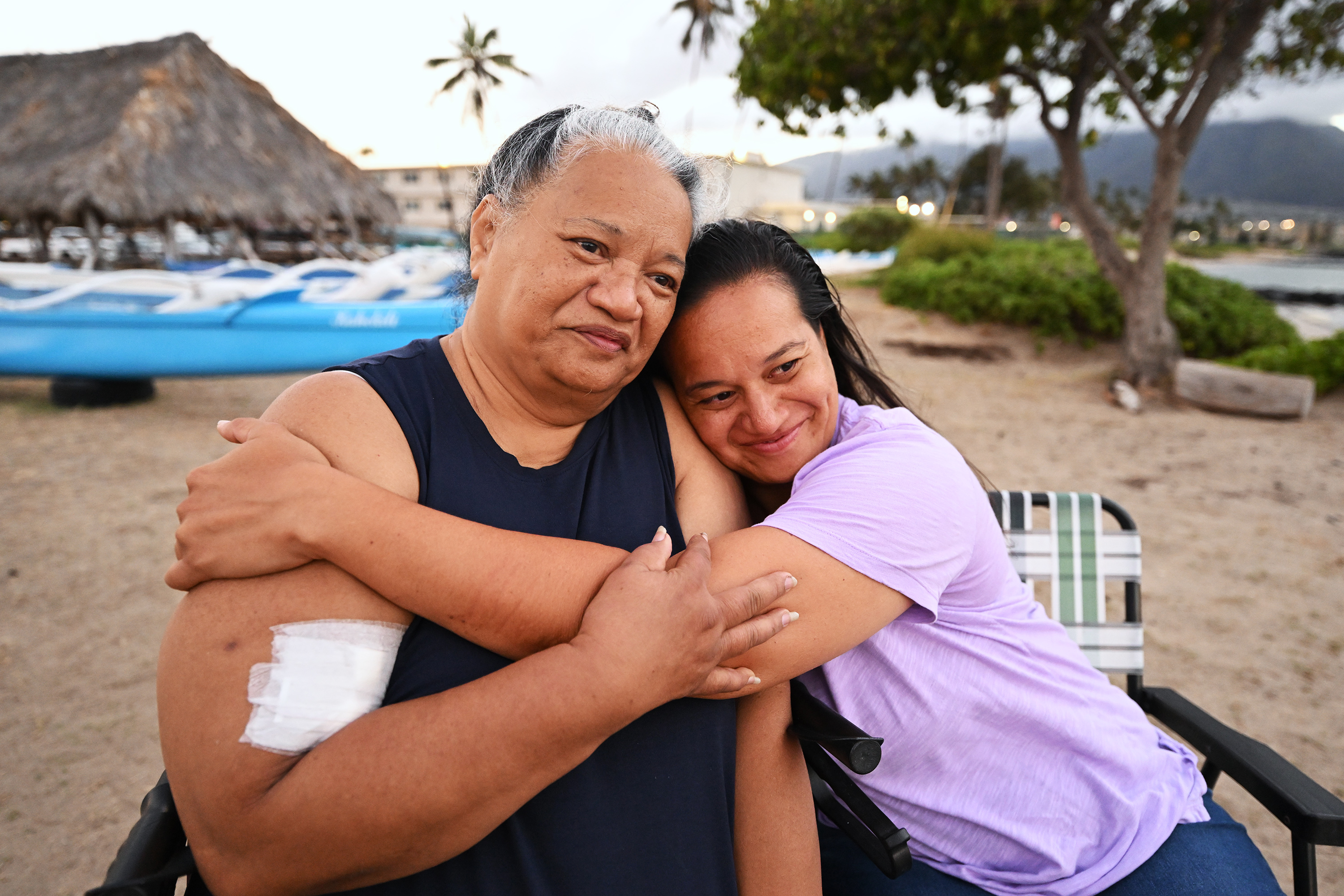 Noni Mirkovich and her daughter, Lani Williams, hug after doing an interview on Thursday, Aug. 17, 2023, talking about their experience of being forced into the ocean to survive the flames in Lahaina, Hawaii. The two and several others had to stay in the water for hours as the fire raged on shore. Response to the Maui fire that destroyed a large portion of the town of Lahaina continue to come in from neighboring islands and the mainland.