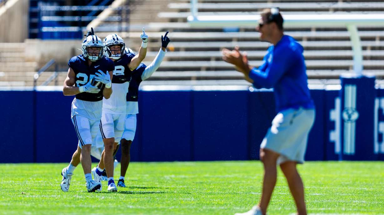 BYU defensive backs celebrate around safety Talan Alfrey (20) after an interception, Aug. 12, 2023, during a training camp scrimmage at LaVell Edwards Stadium in Provo.
