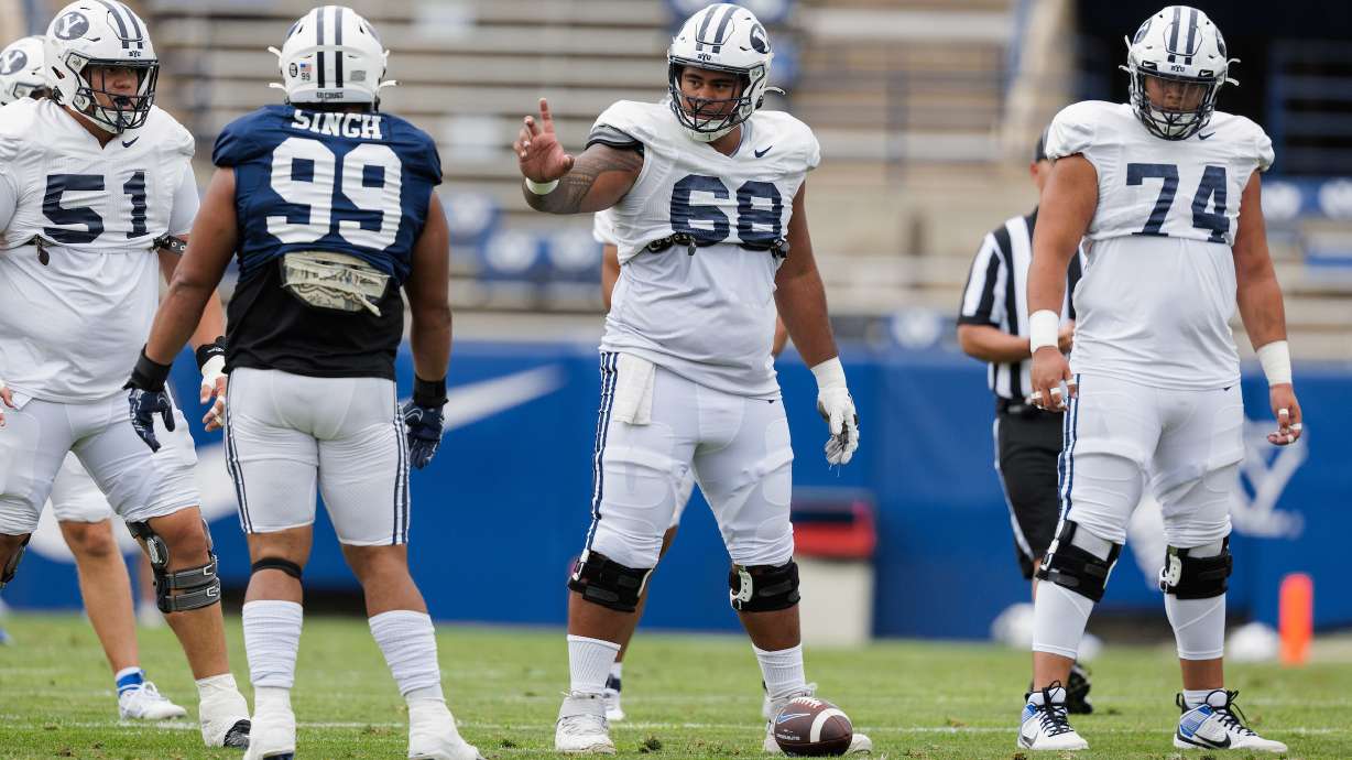 BYU center Paul Maile stands over the football during a scrimmage, Saturday, Aug. 19, 2023, at LaVell Edwards Stadium in Provo.