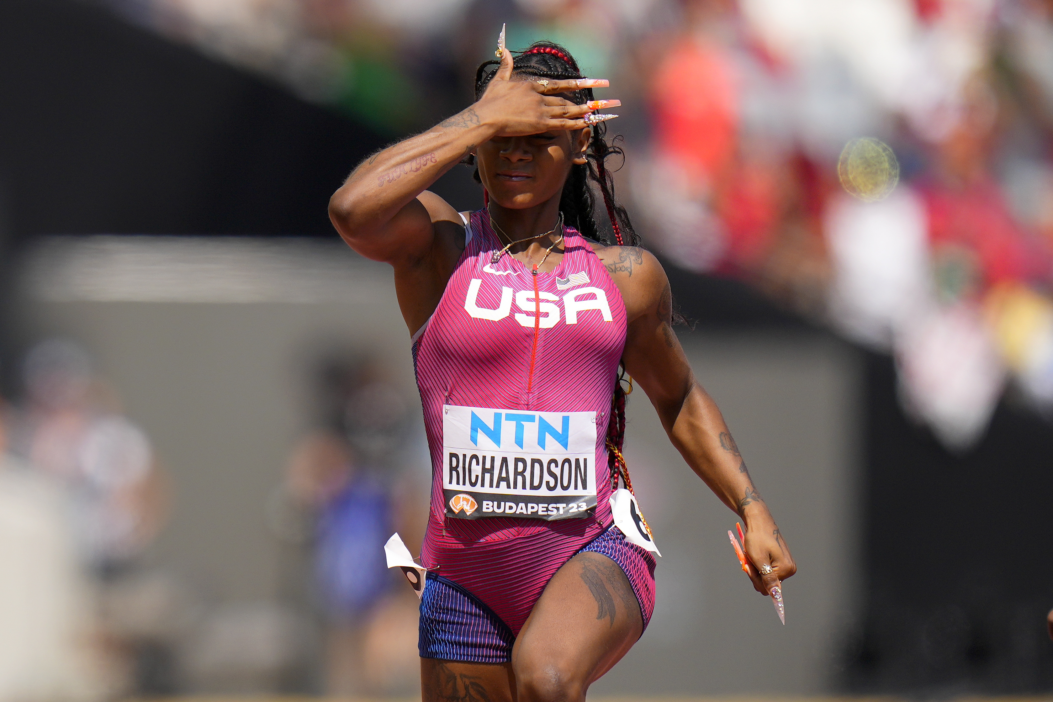 Sha'Carri Richardson, of the United States gestures as she wins a women's 100-meters heat during the World Athletics Championships in Budapest, Hungary, Sunday, Aug. 20, 2023. 